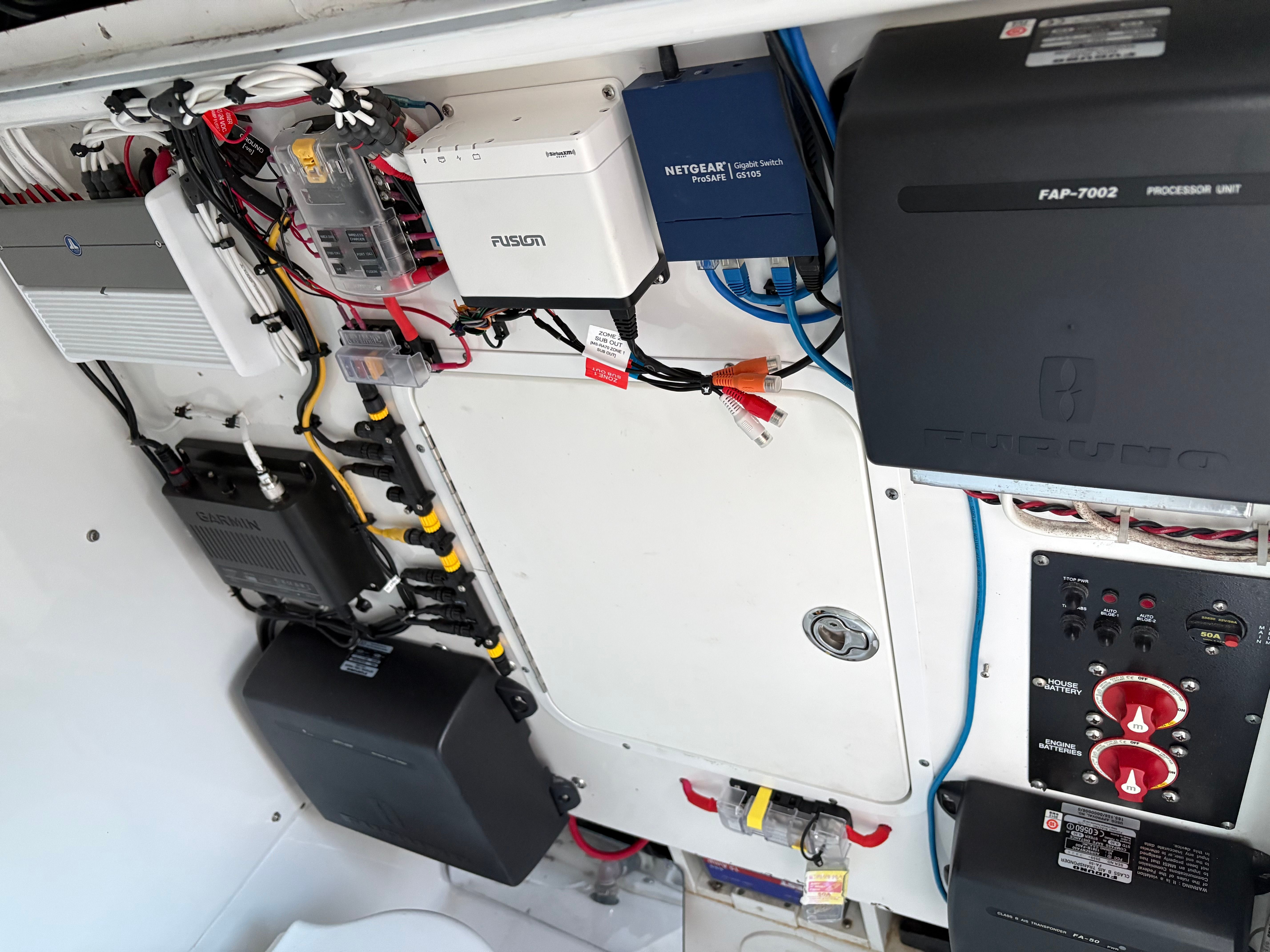 Electronics and control panel in a boat, featuring various devices and wiring.