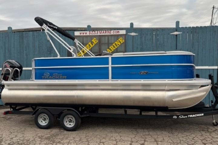2026 Sun Tracker Party Barge 20 DLX pontoon boat on trailer, blue and silver design.