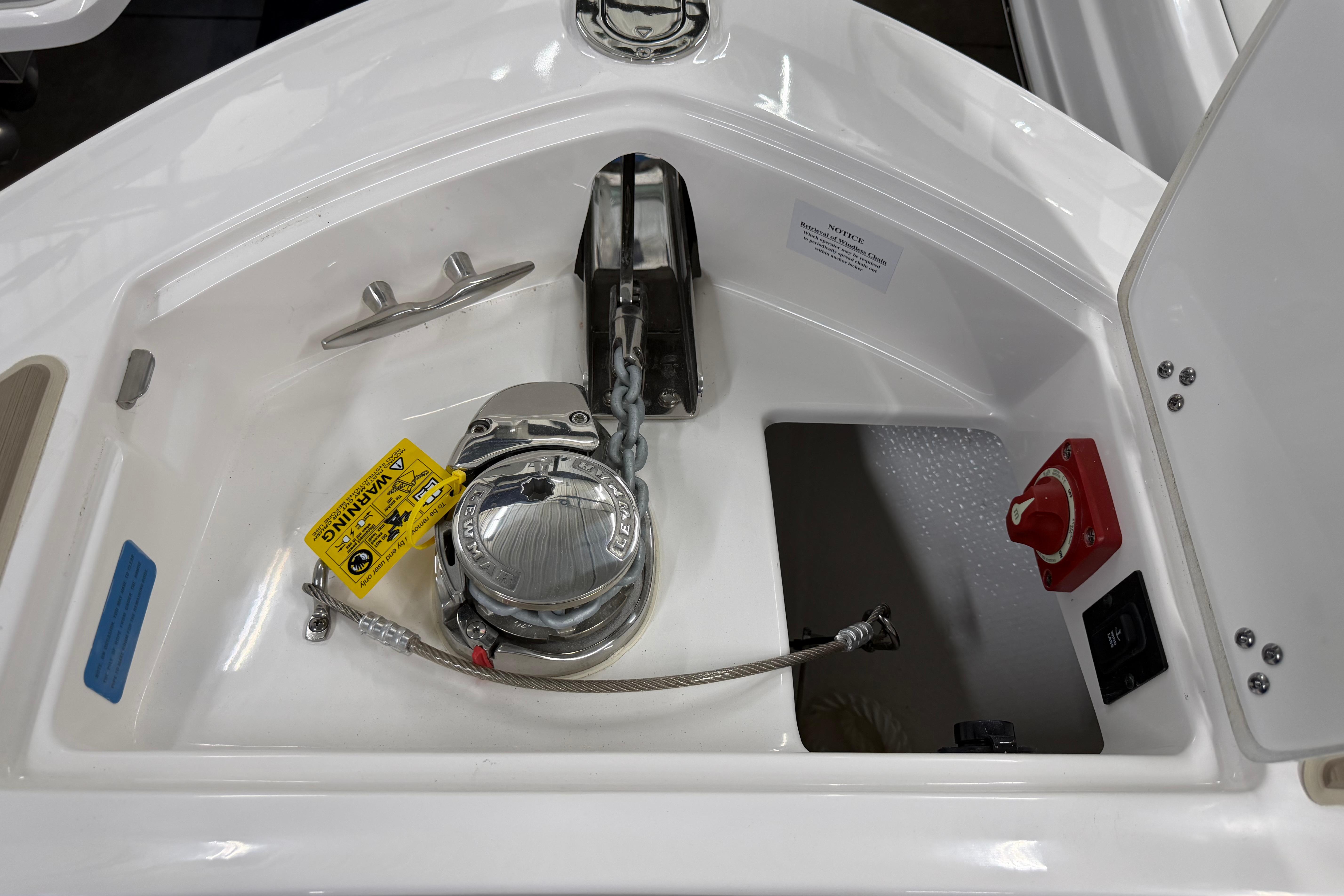 Anchor compartment of 2026 Regal LS6 boat with winch and safety warning.