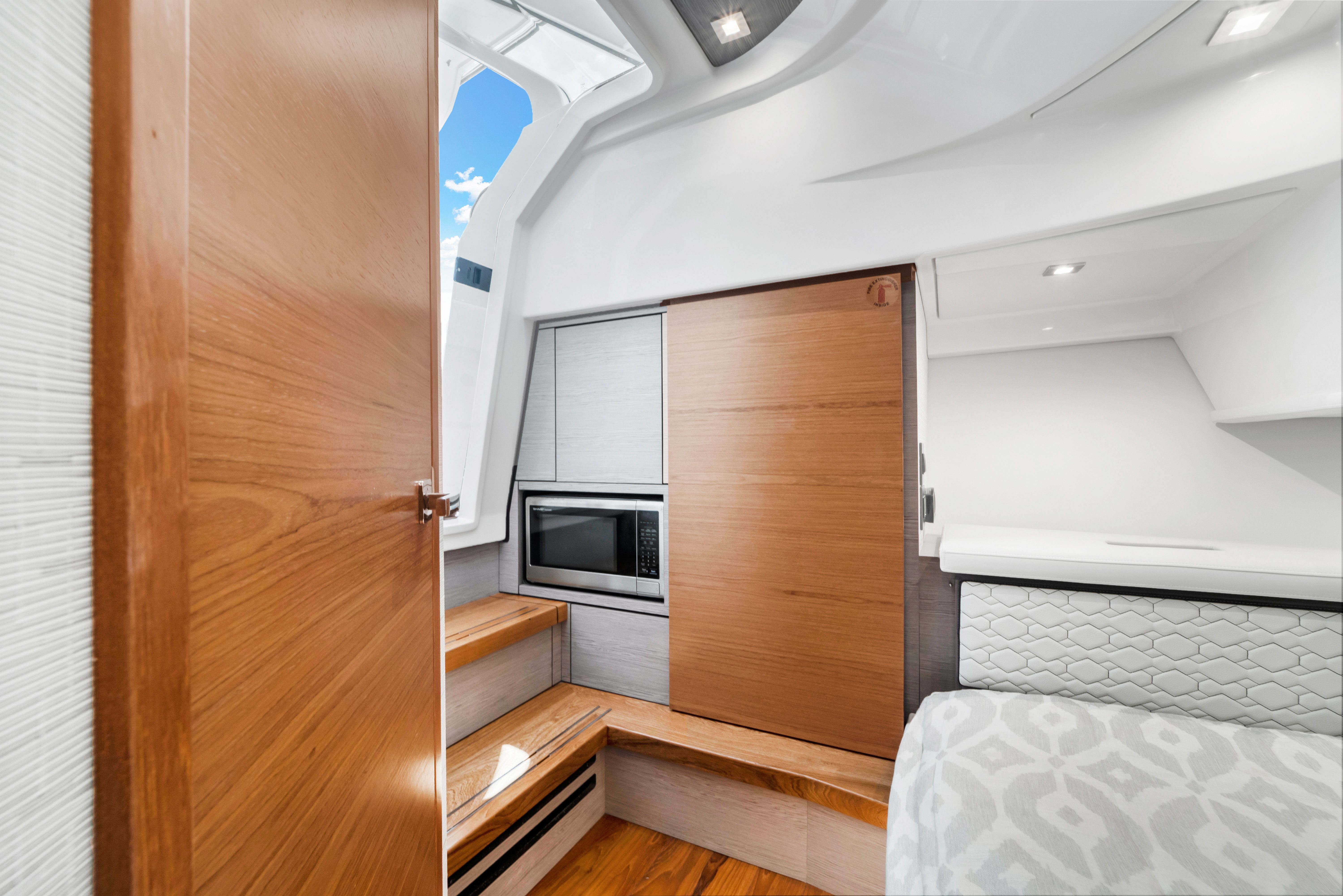 Interior of Tiara Yachts 38 LS with wood paneling, microwave, and stairs.
