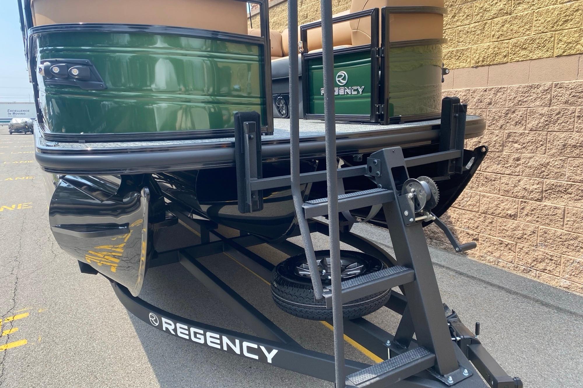 2026 Regency 230 DL pontoon boat on trailer, green exterior, parked outdoors.