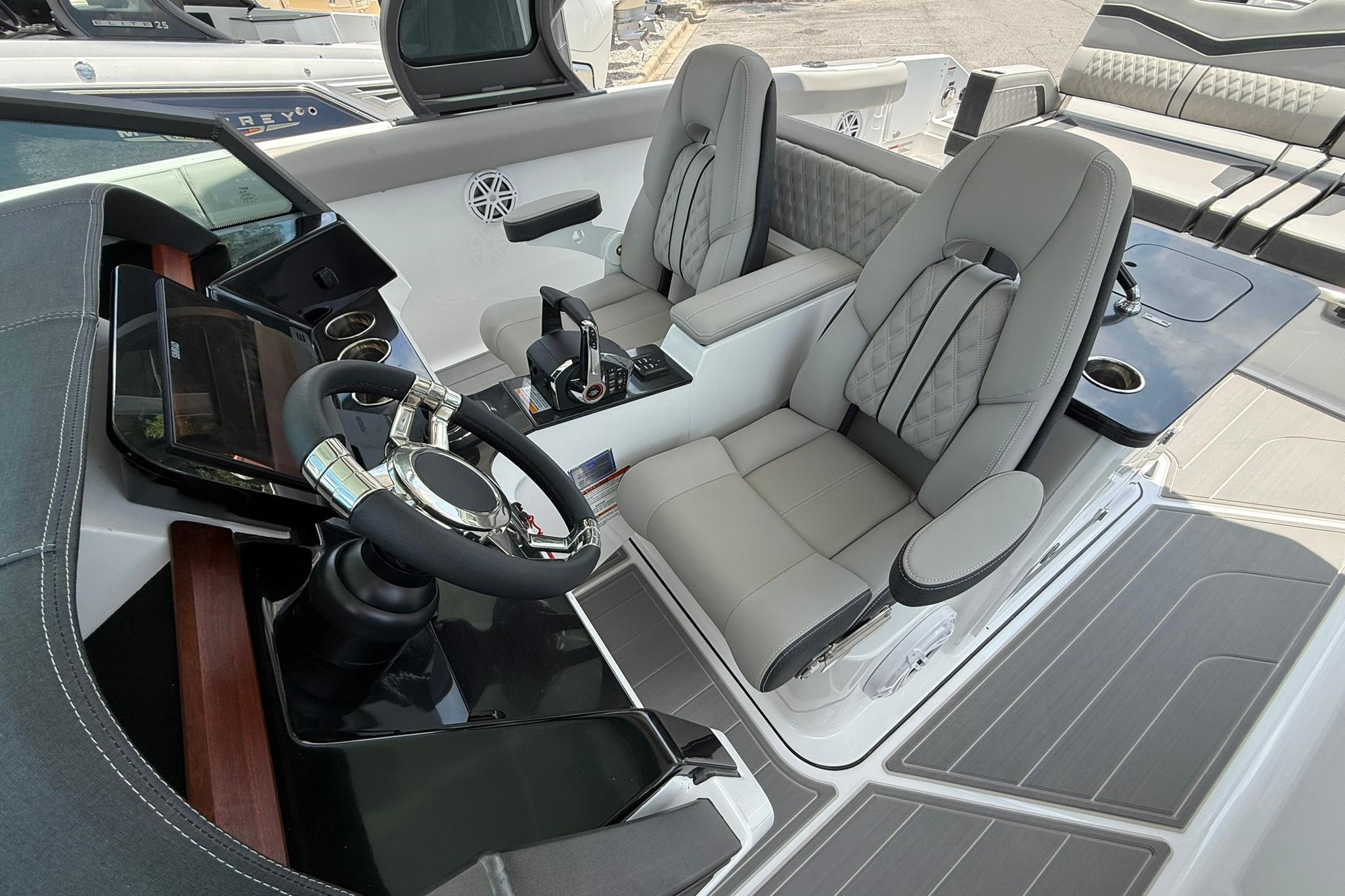 Luxurious cockpit of 2027 Monterey Elite 30 OB boat with modern steering and seating.