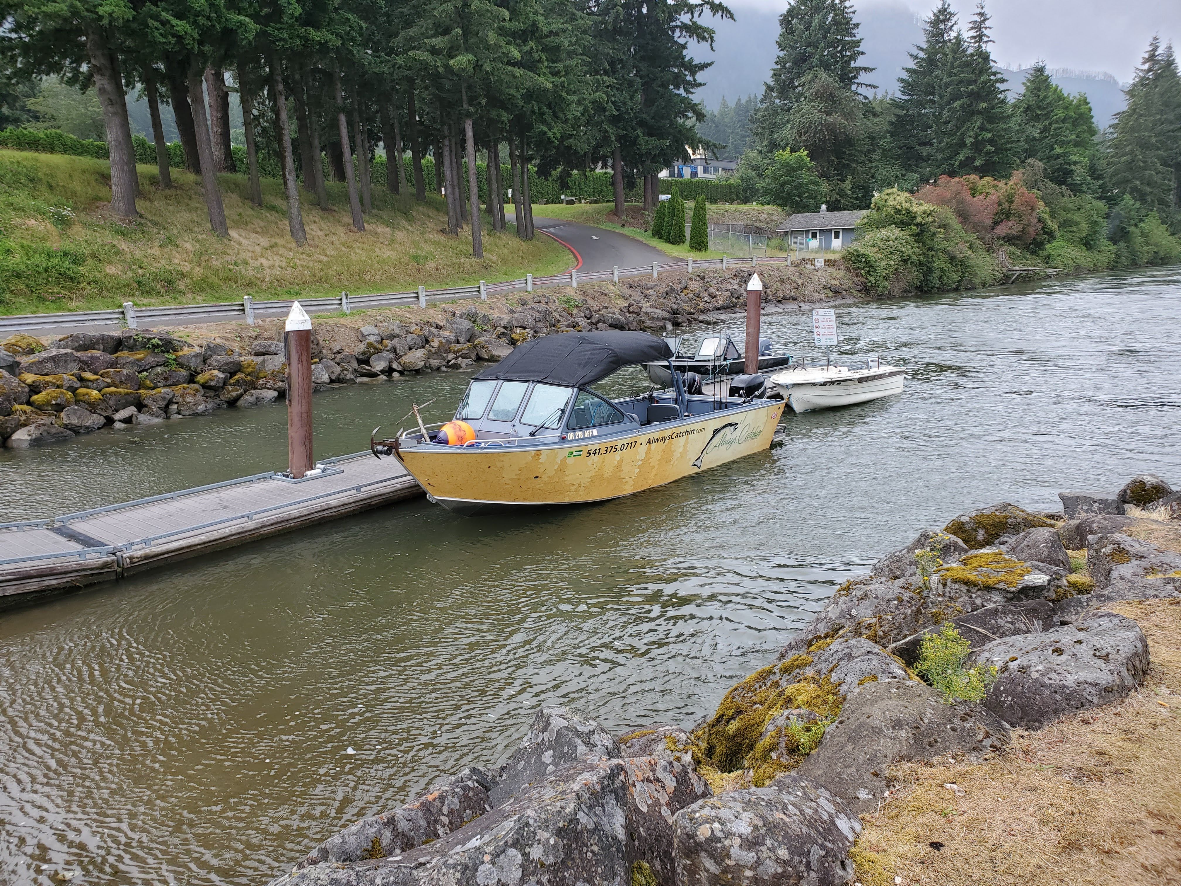 A 2015 Alumaweld Formula Vee Outboard 24 is docked at a calm riverside pier.