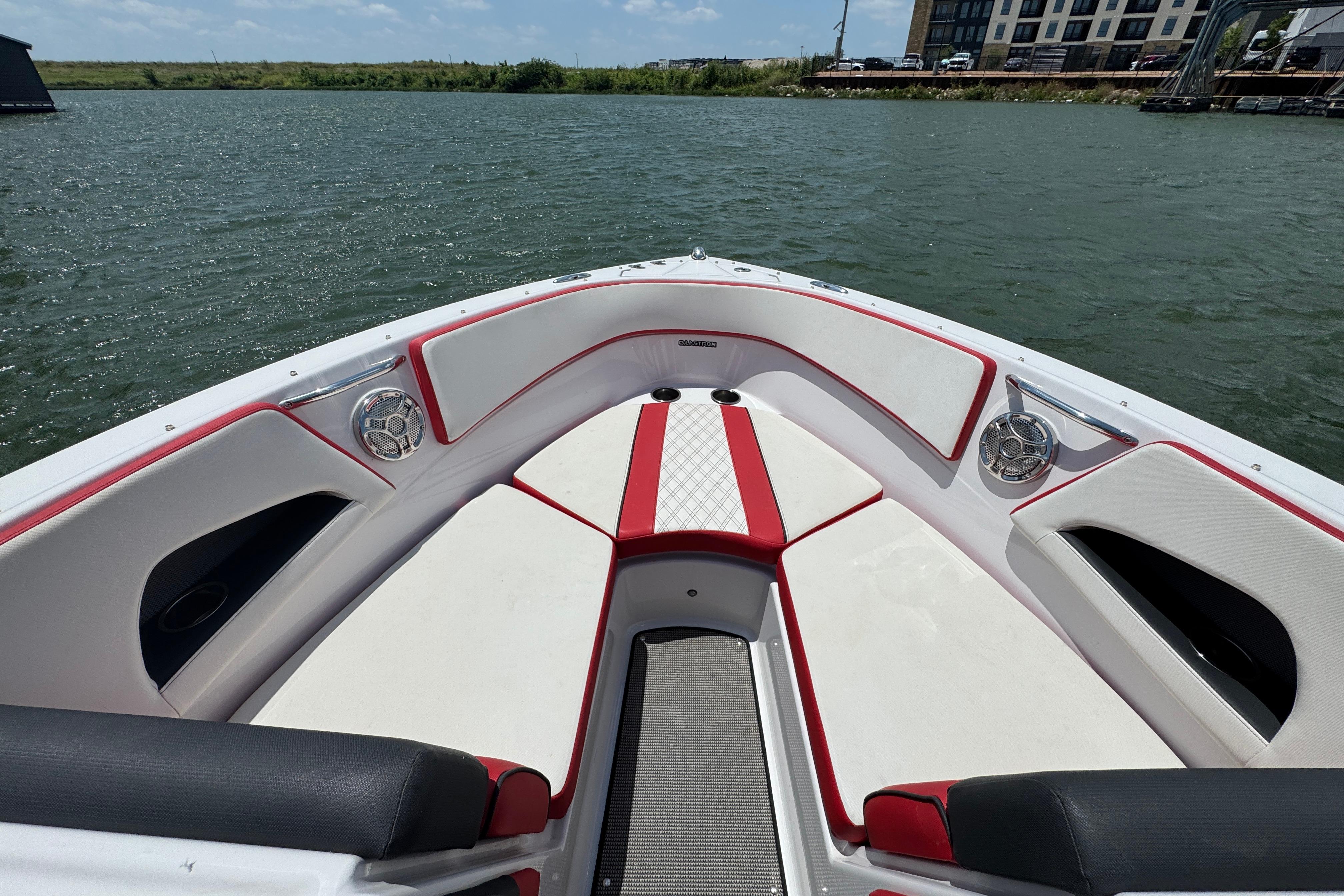 2017 Glastron GT 225 boat interior with red and white seating on a lake.