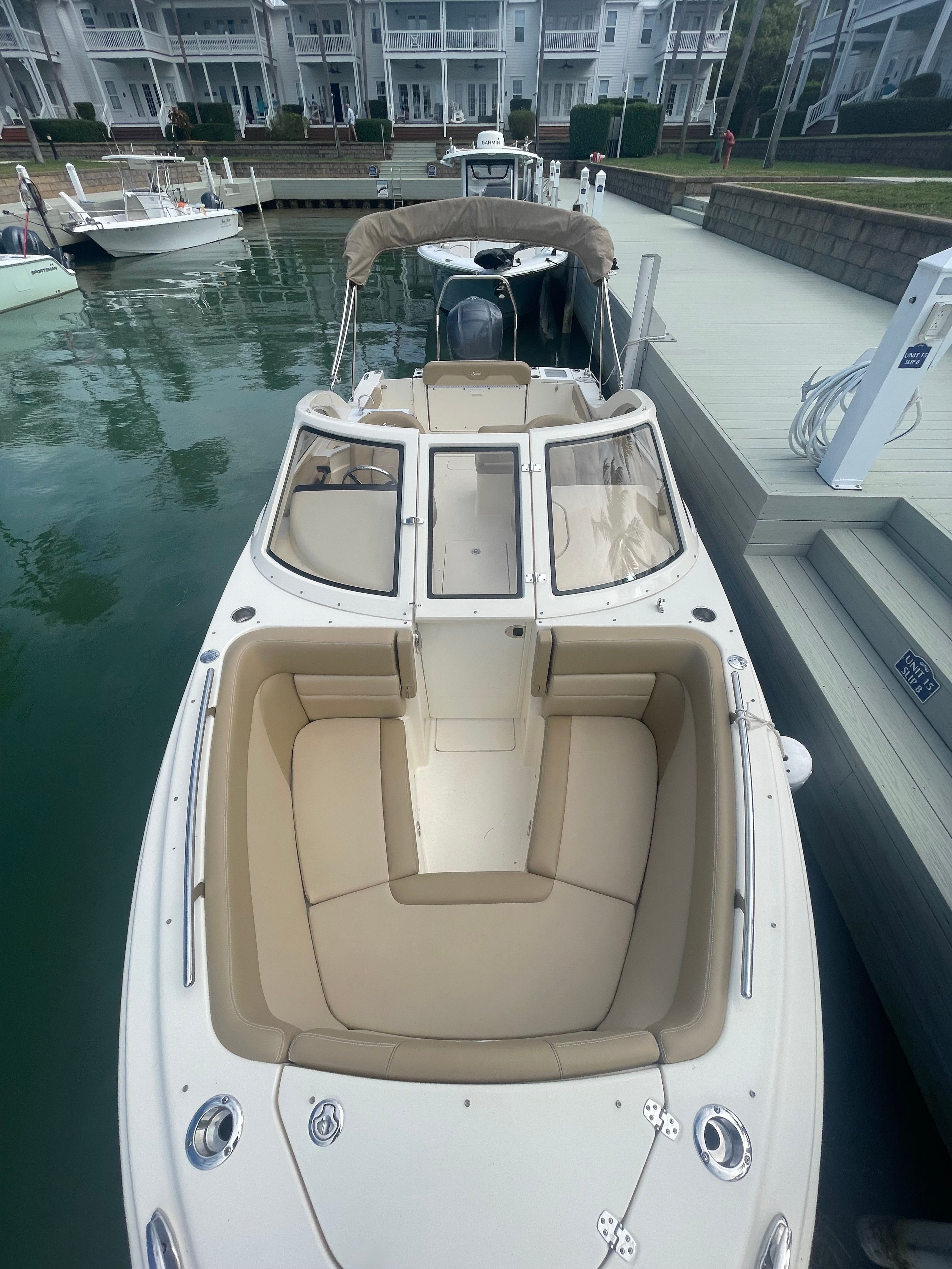 A 2020 Scout 235 Dorado docked, featuring beige upholstery and an open deck.