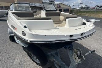2017 Bayliner 195 Deck Boat on trailer, parked outdoors, showcasing spacious seating and sleek design.