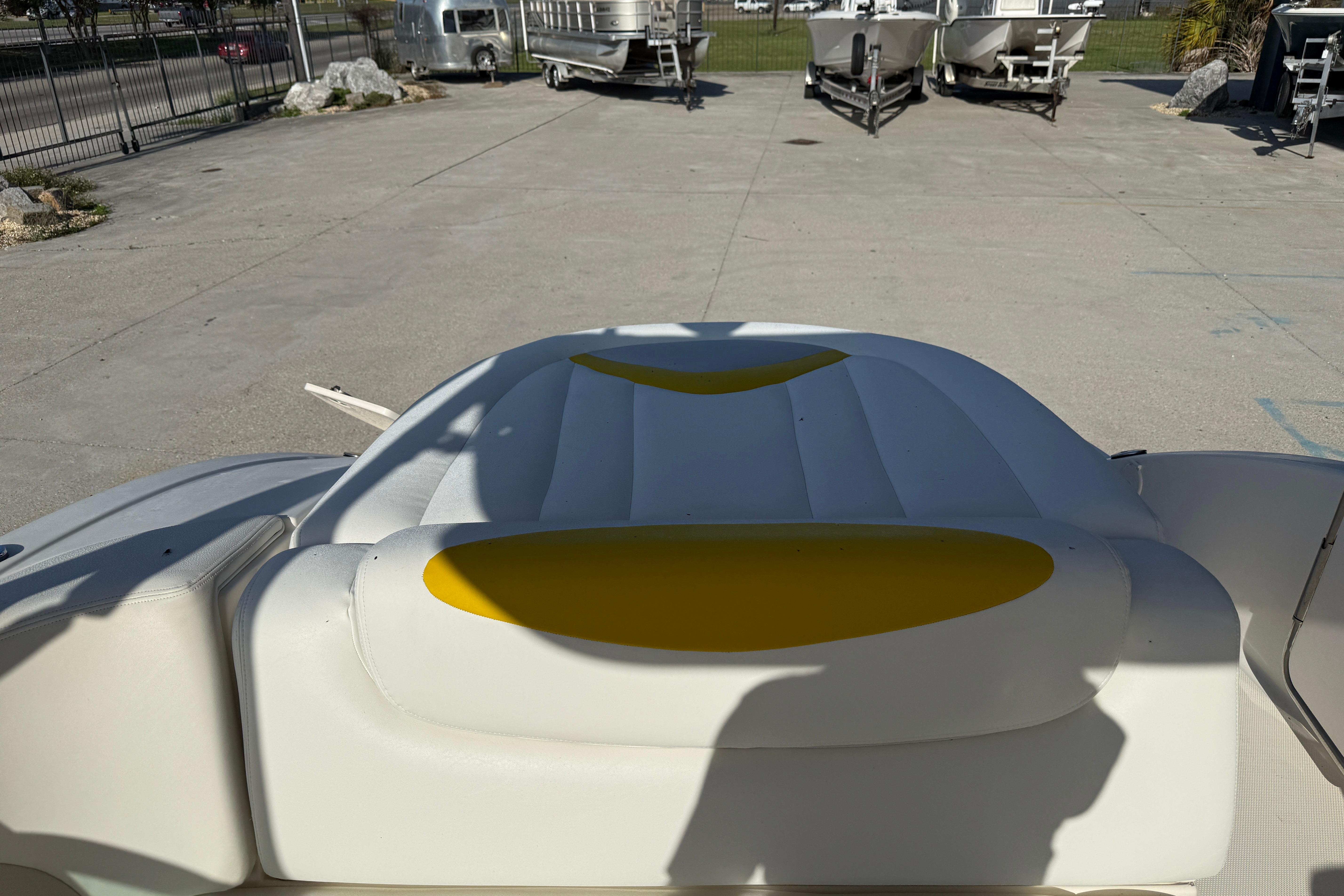 2008 Chaparral 236 SSX boat interior with white and yellow seating, parked outdoors.