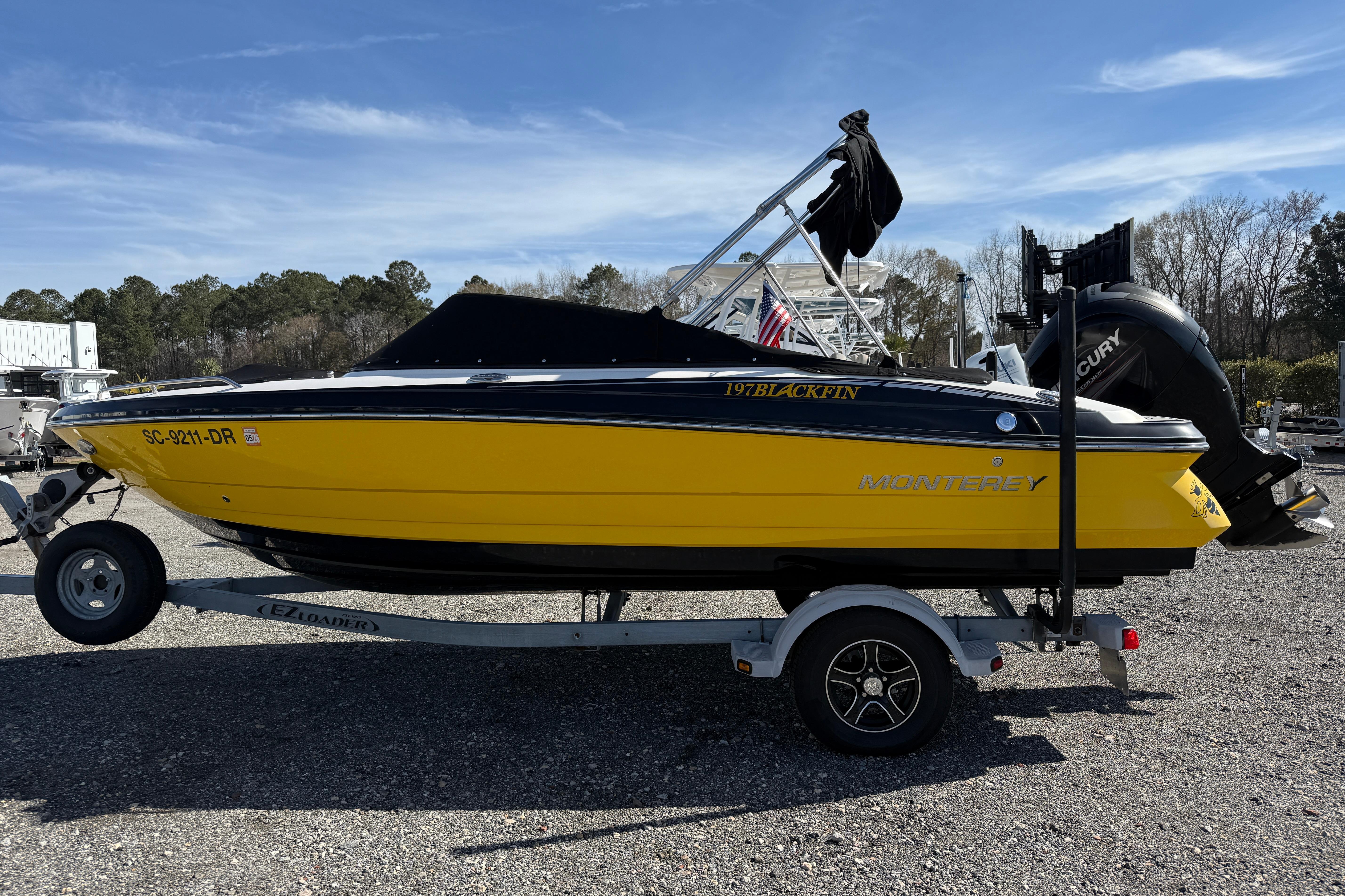 2014 Monterey 197 Blackfin boat in bright yellow on a trailer, parked outdoors.