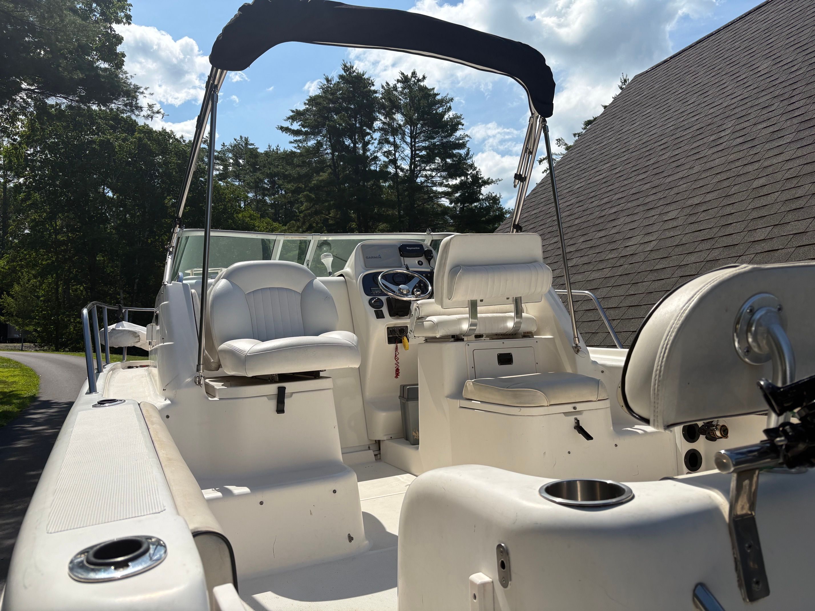 The image shows the cockpit of a 2006 Robalo R265 Walkaround boat with white seating.