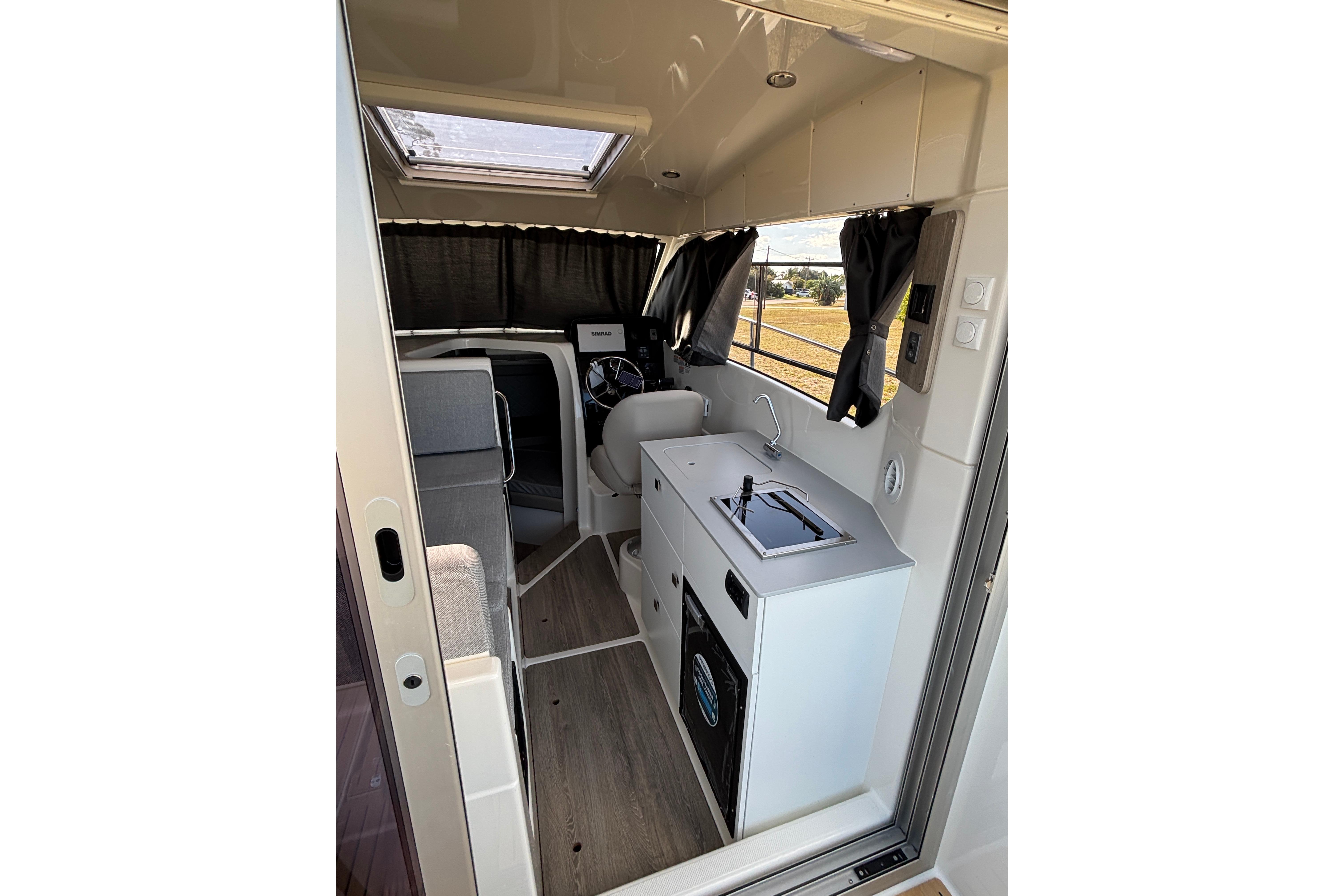 Interior of 2026 Trophy T 25 Explorer boat with kitchenette and seating area.