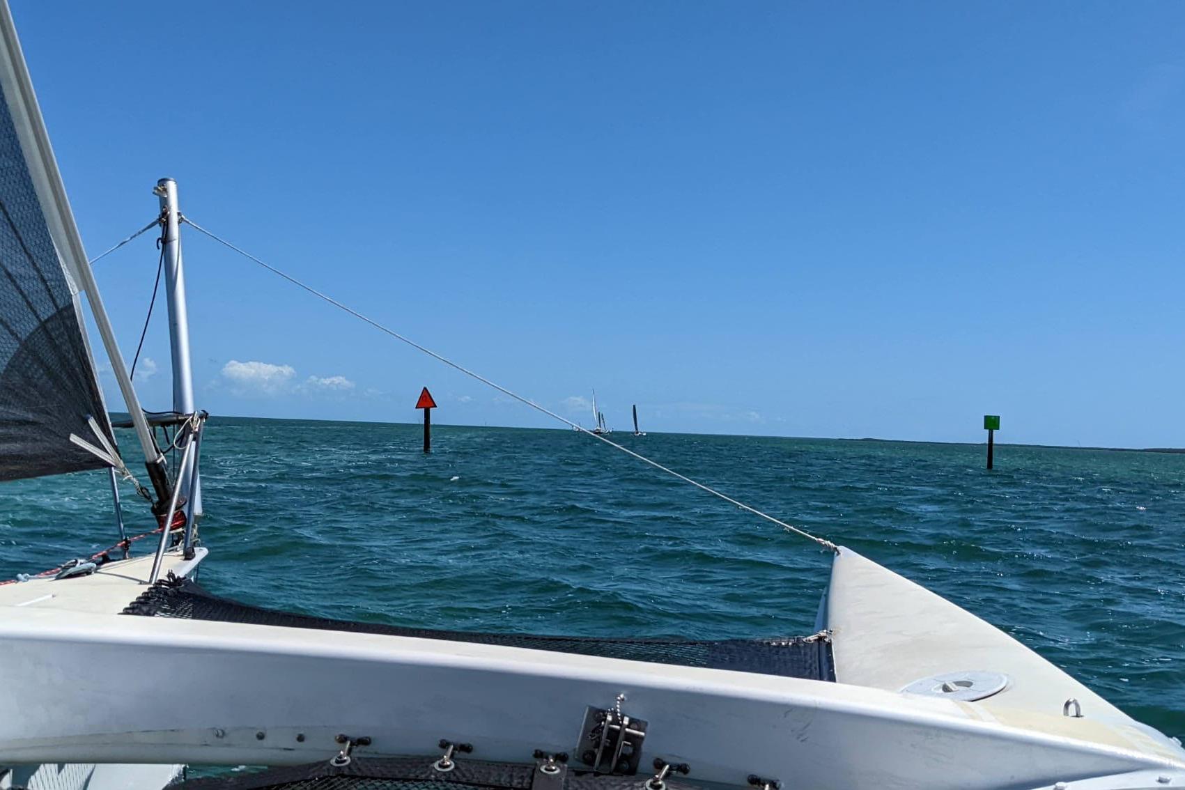 Sailing on a 1991 Corsair F-27 trimaran in clear blue waters under a sunny sky.