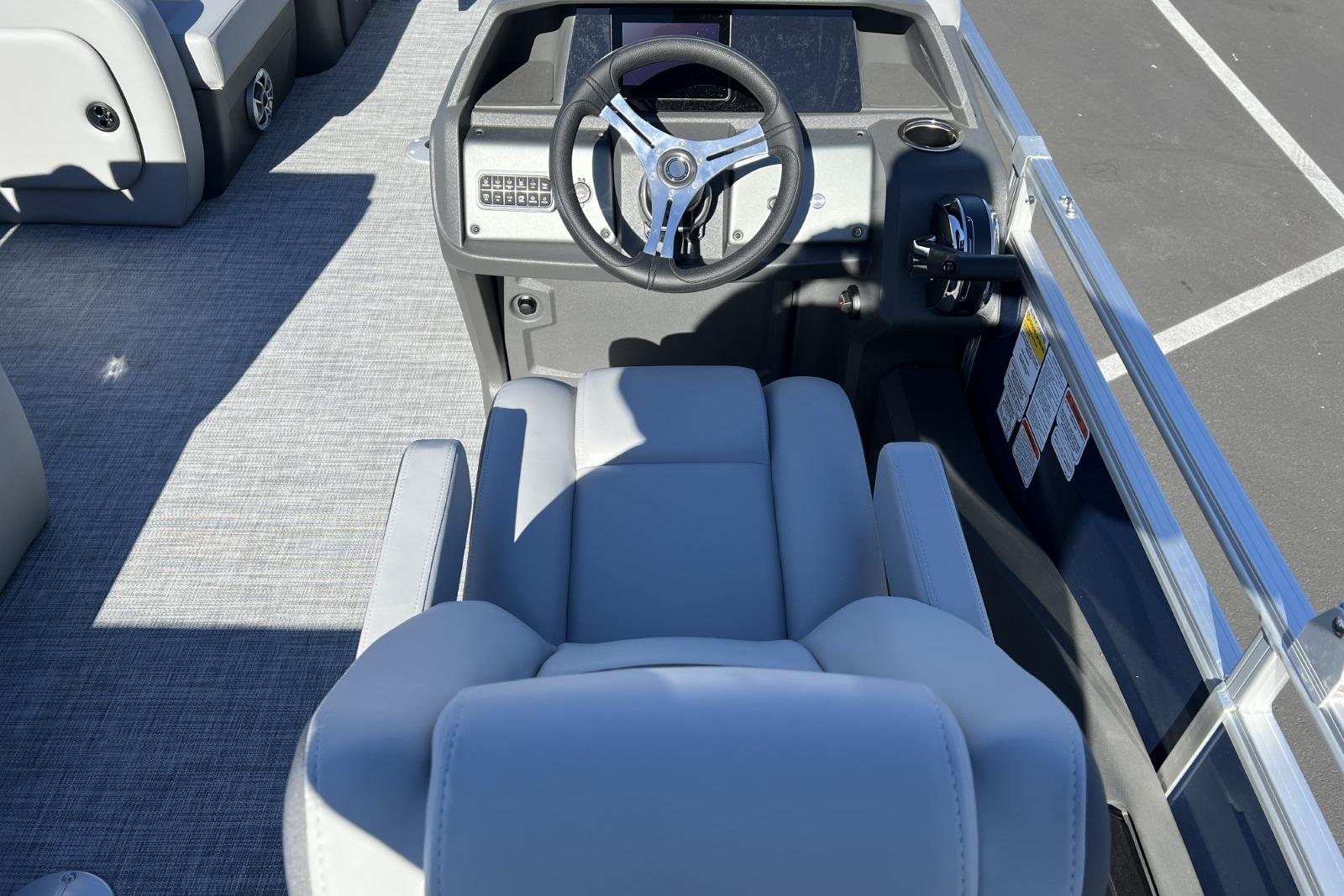 2026 Sun Tracker SportFish 22 DLX boat interior with steering wheel and seating.