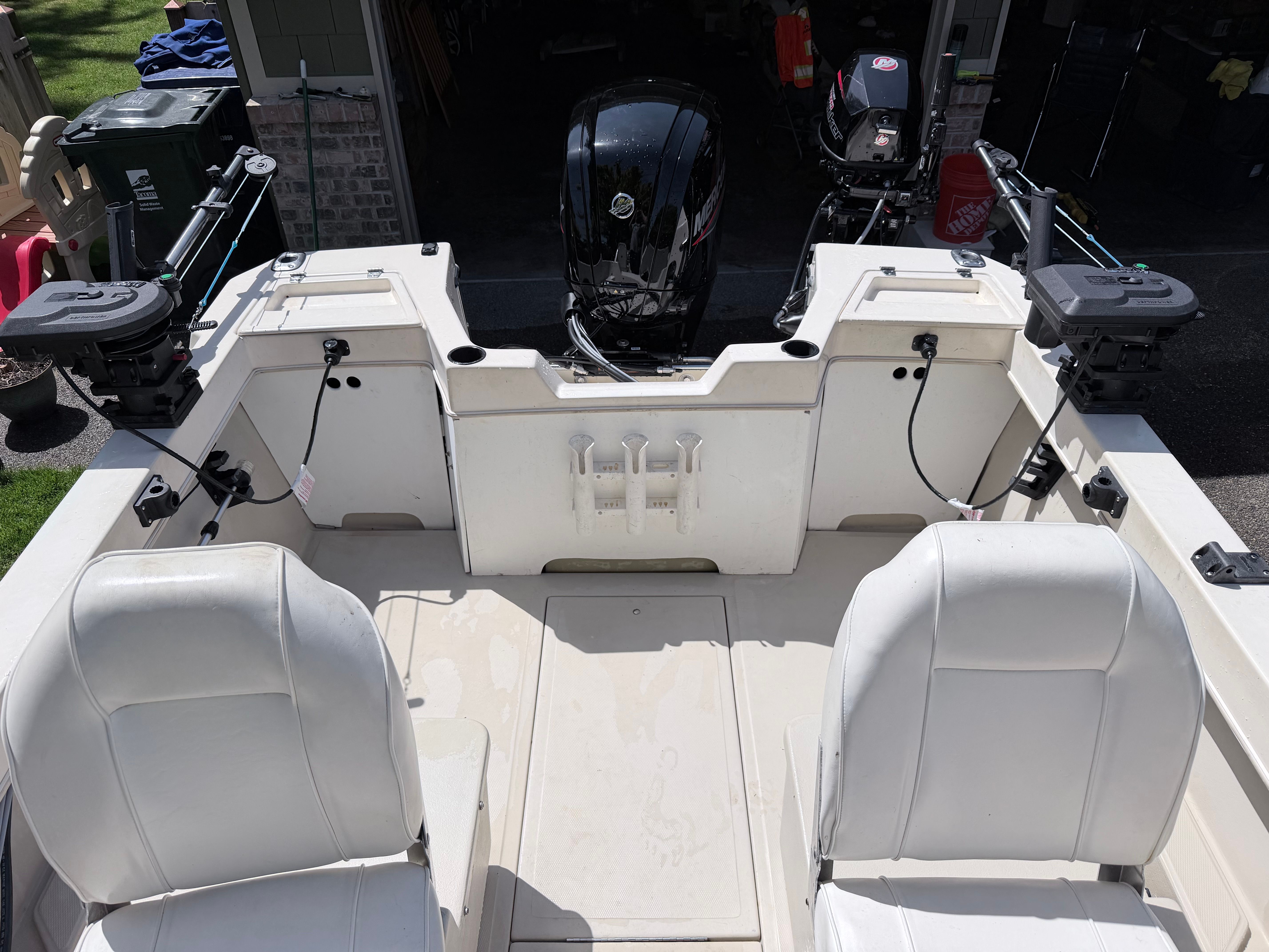 The image shows the cockpit of an Arima Sea Explorer 1511 with two white seats and two outboard motors.
