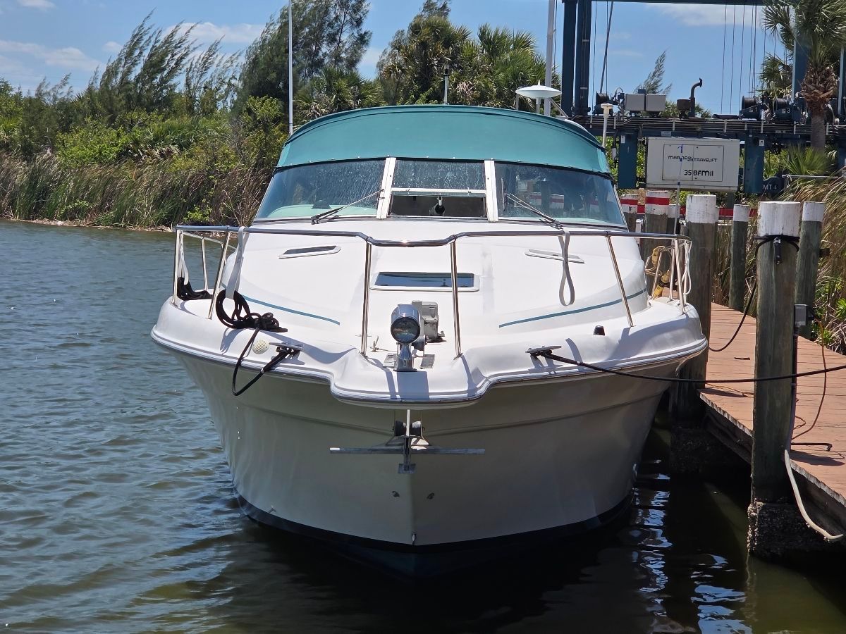 A 1995 Sea Ray Sundancer 330 docked. It features a green canopy.