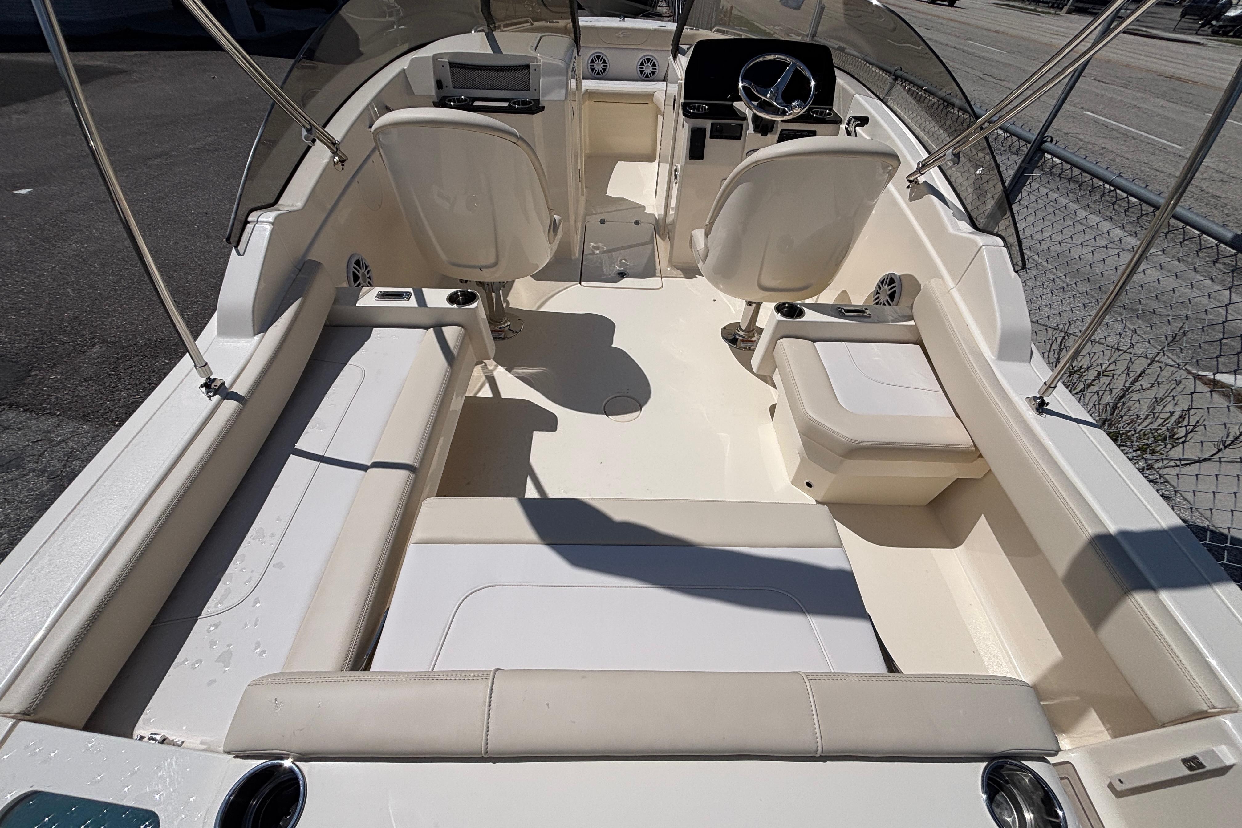 2026 Scout 220 Dorado boat interior with seating and steering wheel, docked outdoors.