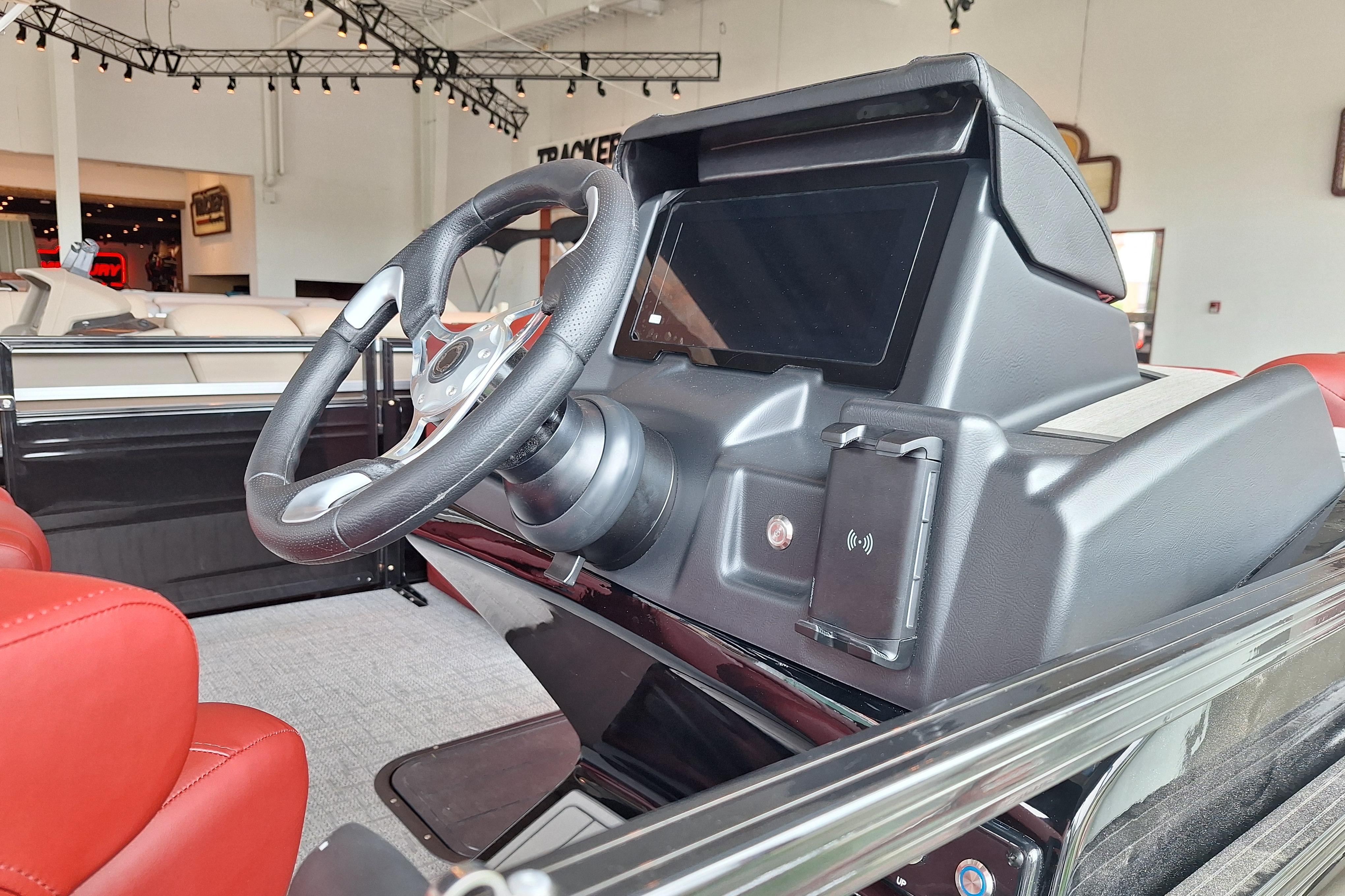 2026 Regency 230 DL boat dashboard with steering wheel and modern controls in showroom.