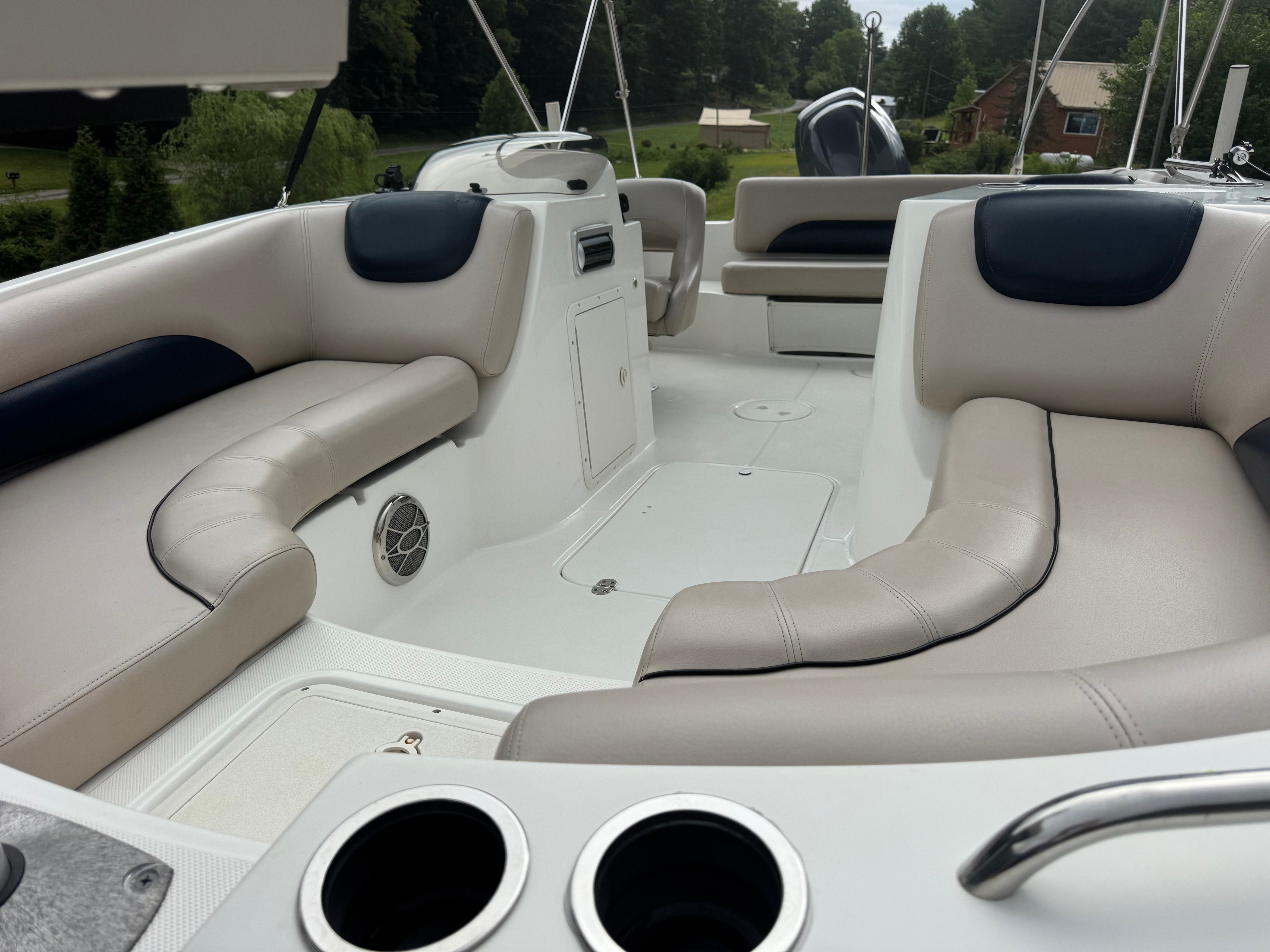 Interior of a Hurricane SunDeck Sport 188 IO boat with beige seating and cup holders.
