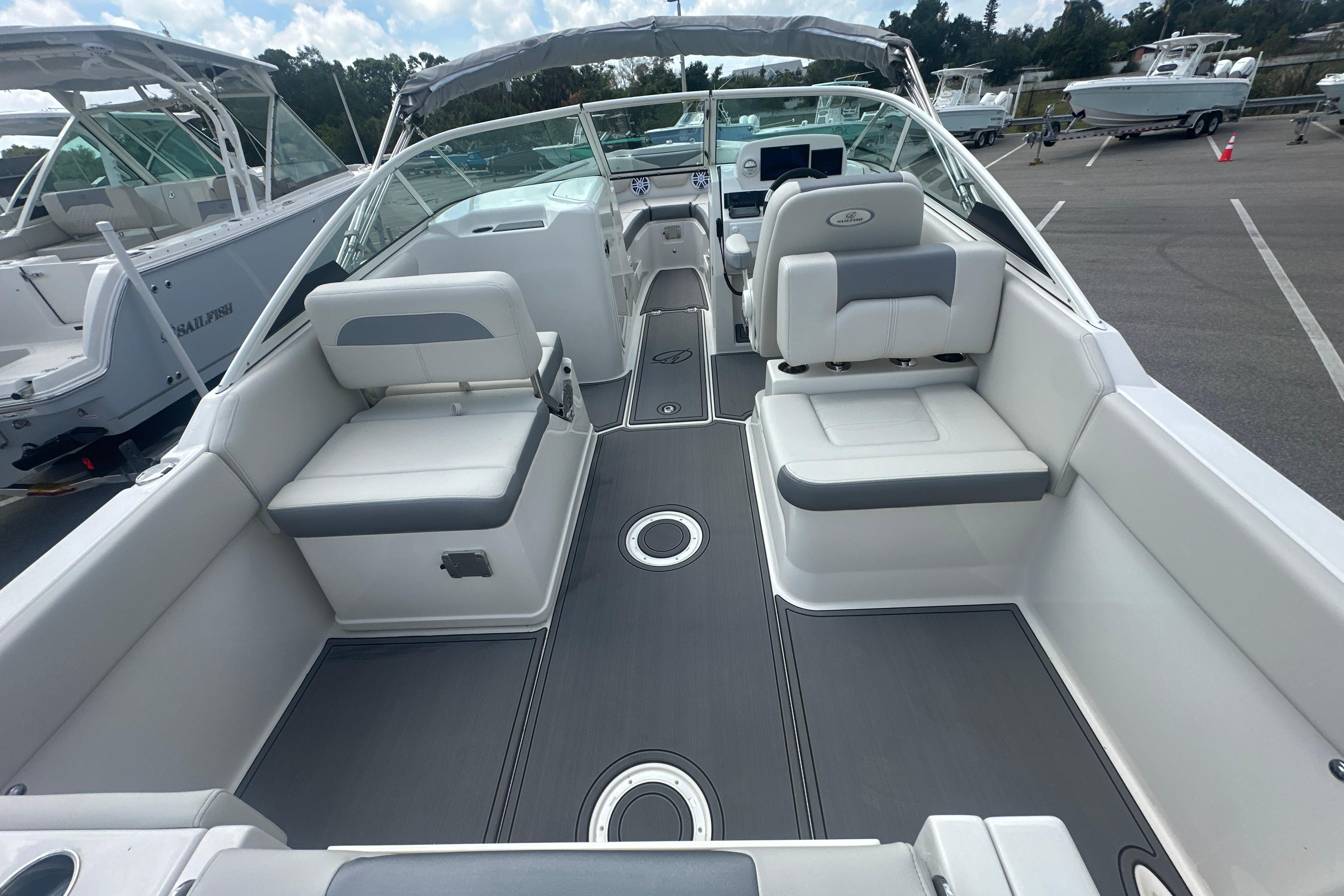 2026 Sailfish 226 DC boat interior with gray and white seating, docked outdoors.