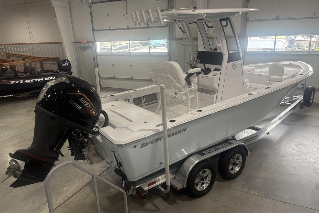 2026 Sportsman Masters 227 boat in showroom, featuring dual-axle trailer and powerful outboard motor.