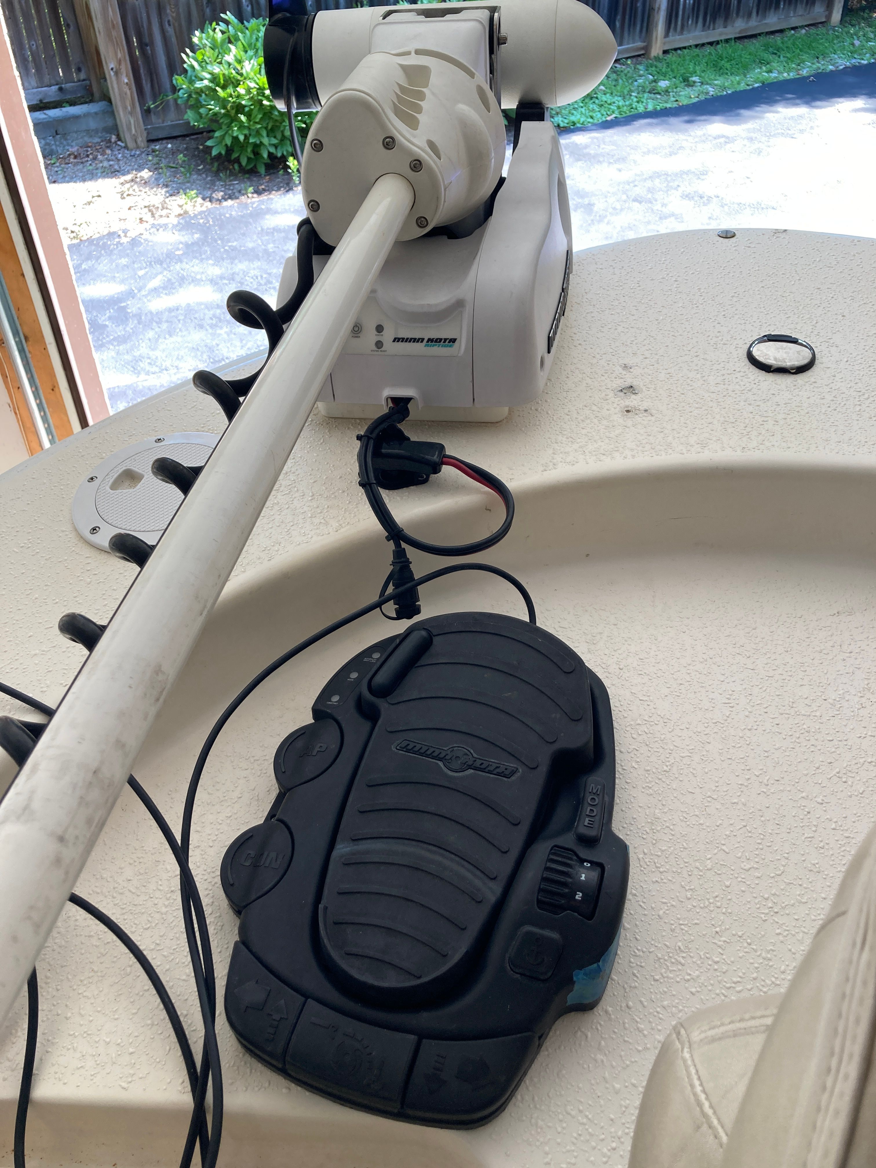 Close-up of a boat deck with a trolling motor and control.