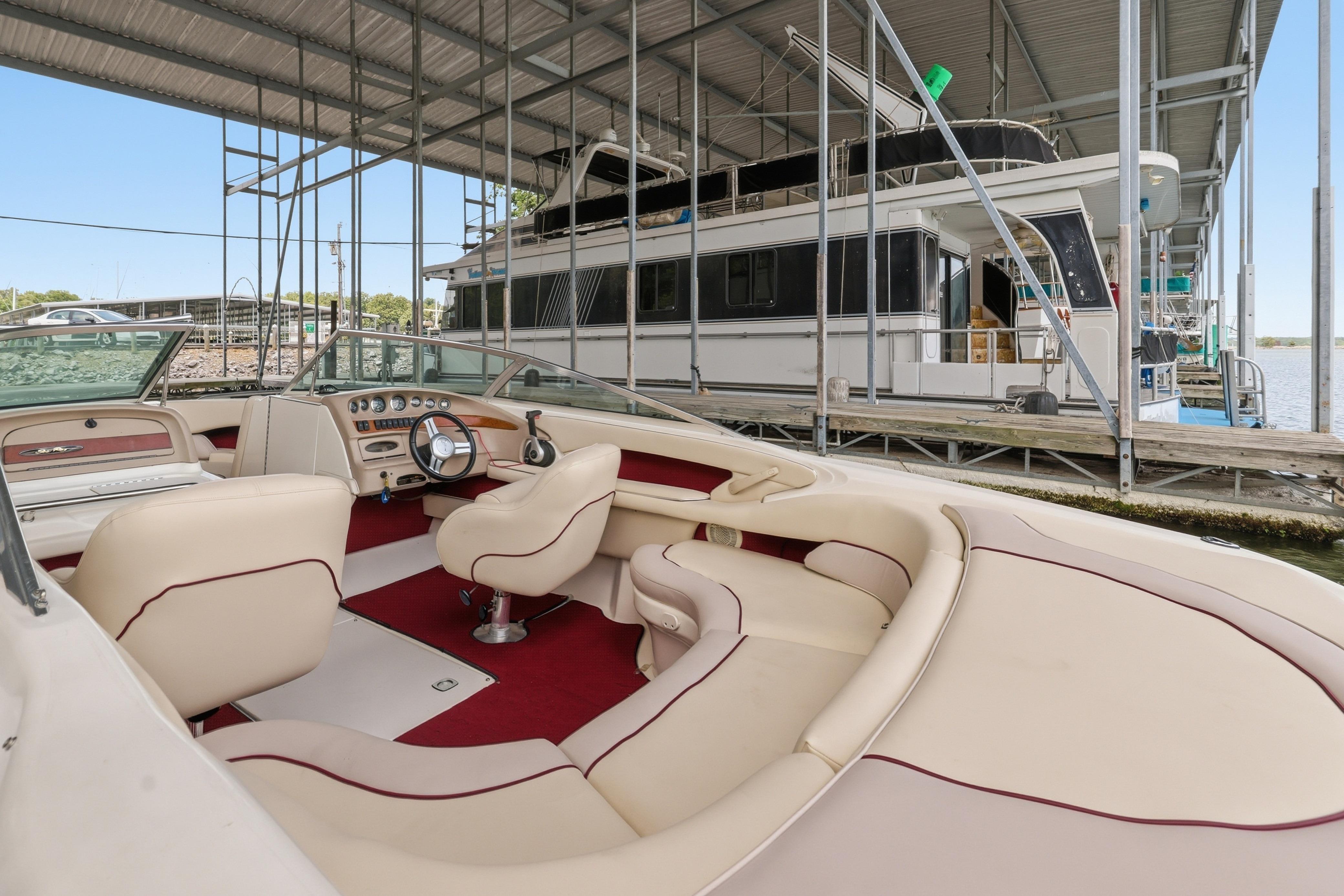 1997 Sea Ray 230 Signature boat interior at marina, featuring cream and red upholstery.