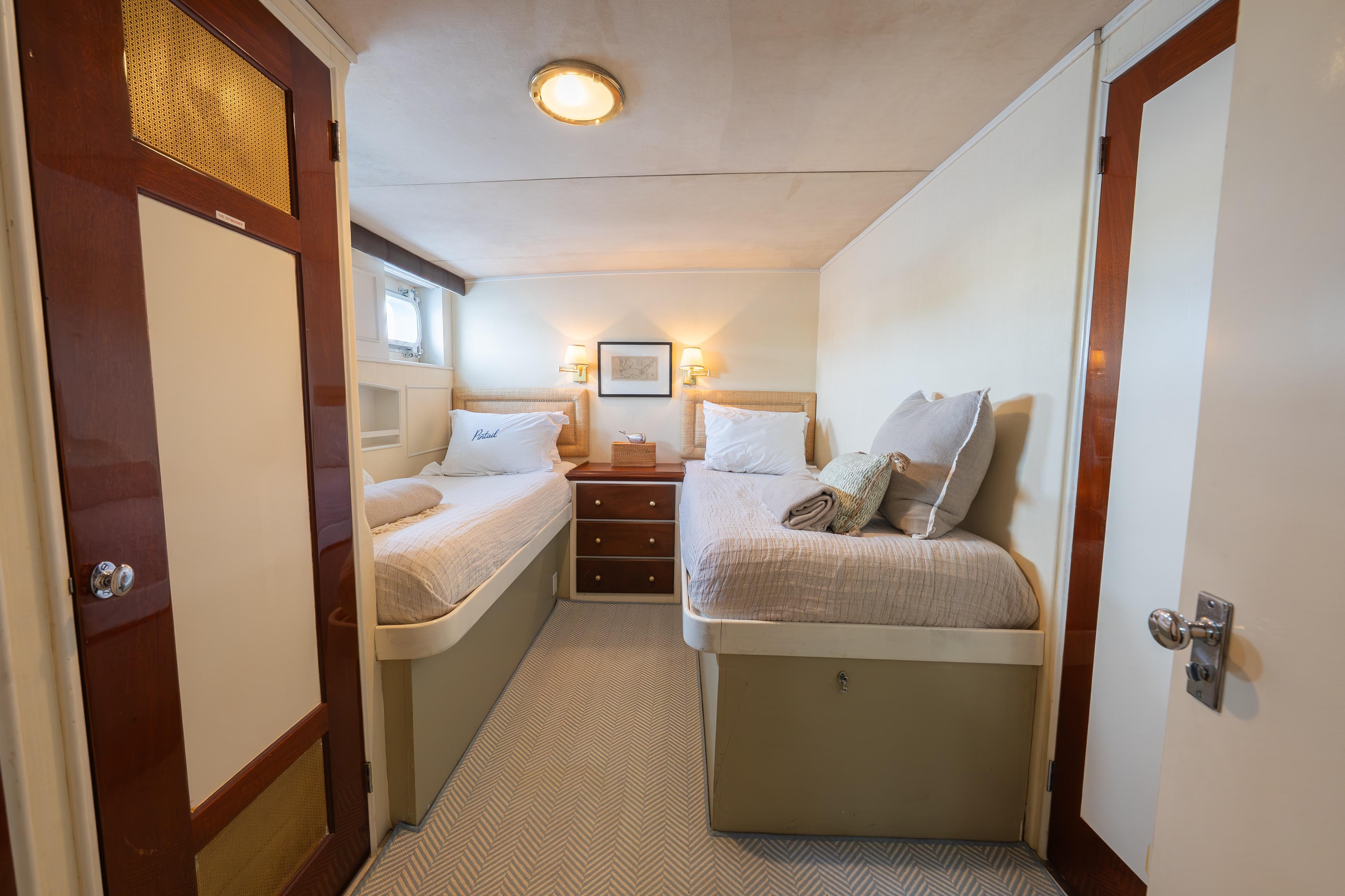 Cozy twin bedroom on 1963 Trumpy Classic yacht with elegant wood accents.