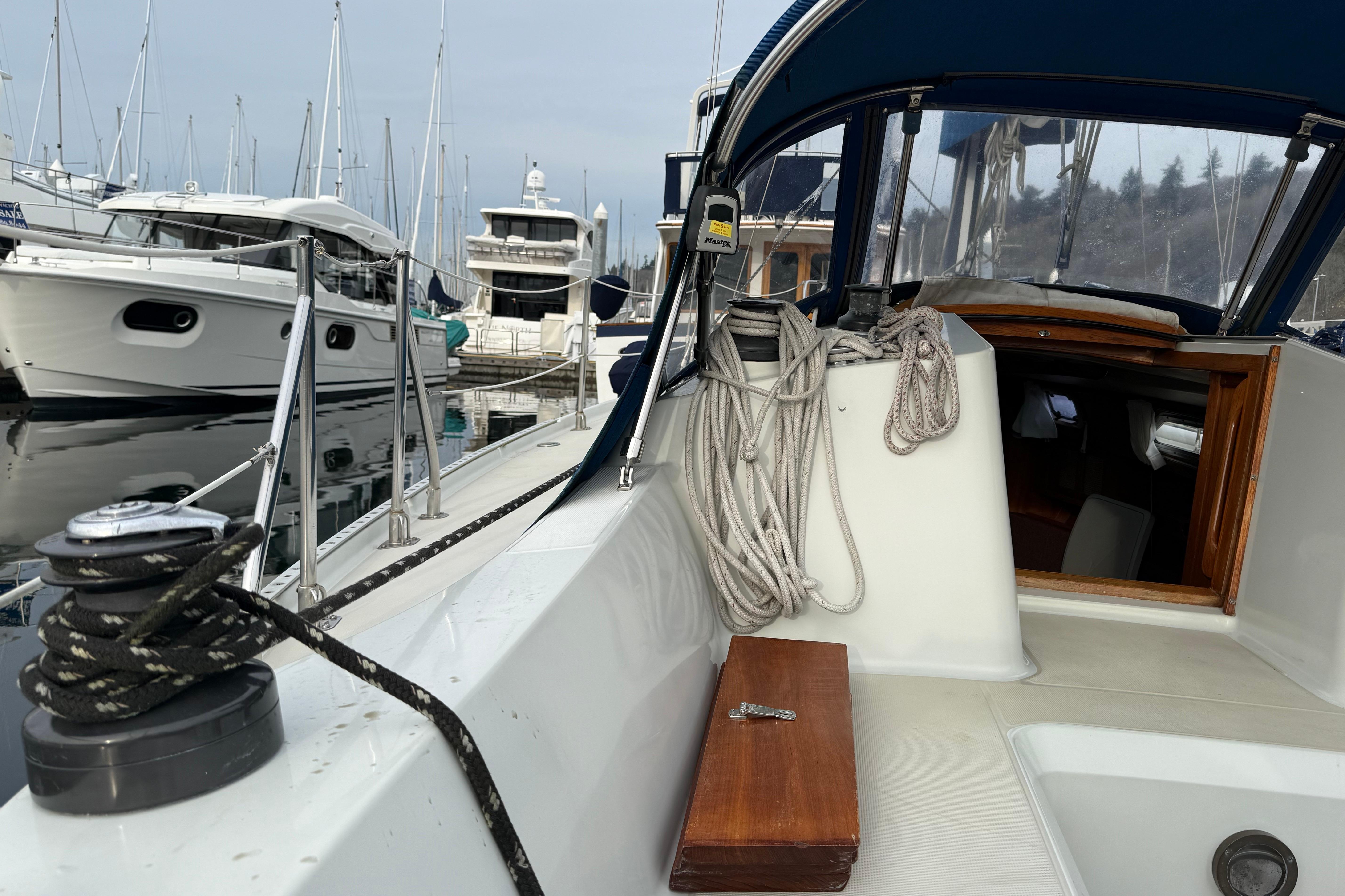 1988 Ericson 32-200 sailboat docked at marina, featuring deck and rigging details.