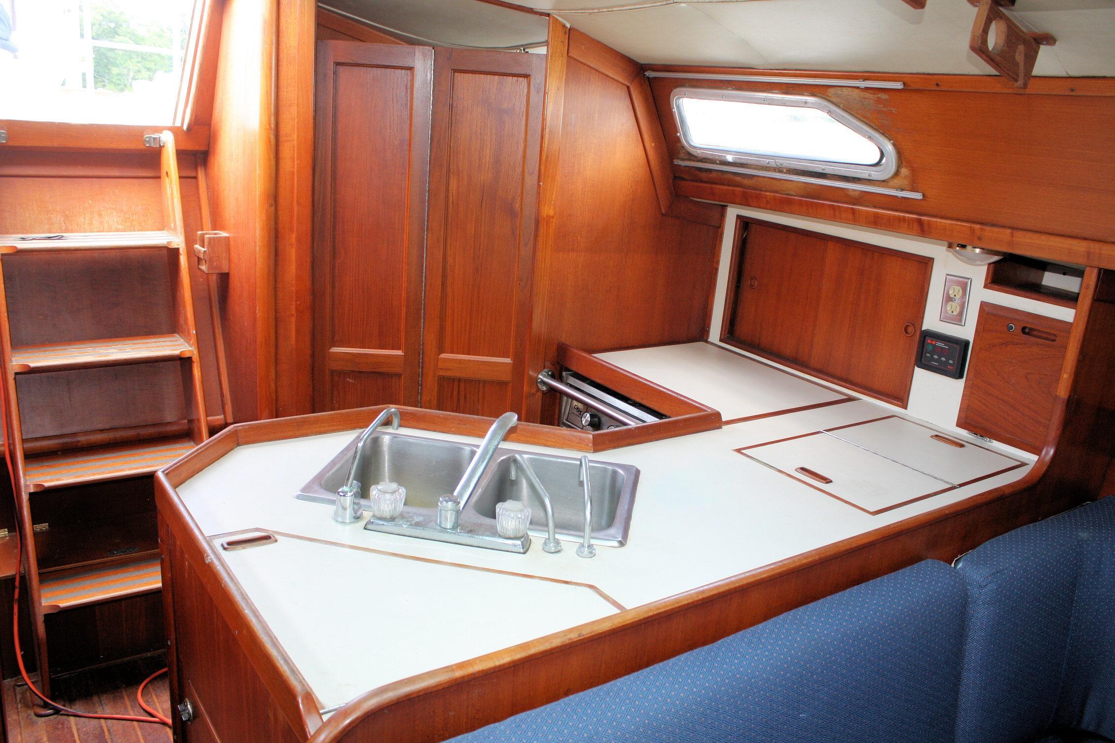 Interior of 1987 Ericson 38-200 sailboat featuring a wooden galley with sink and storage.