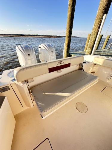 2023 Cobia 301 Center Console boat with twin outboard engines docked by the water.