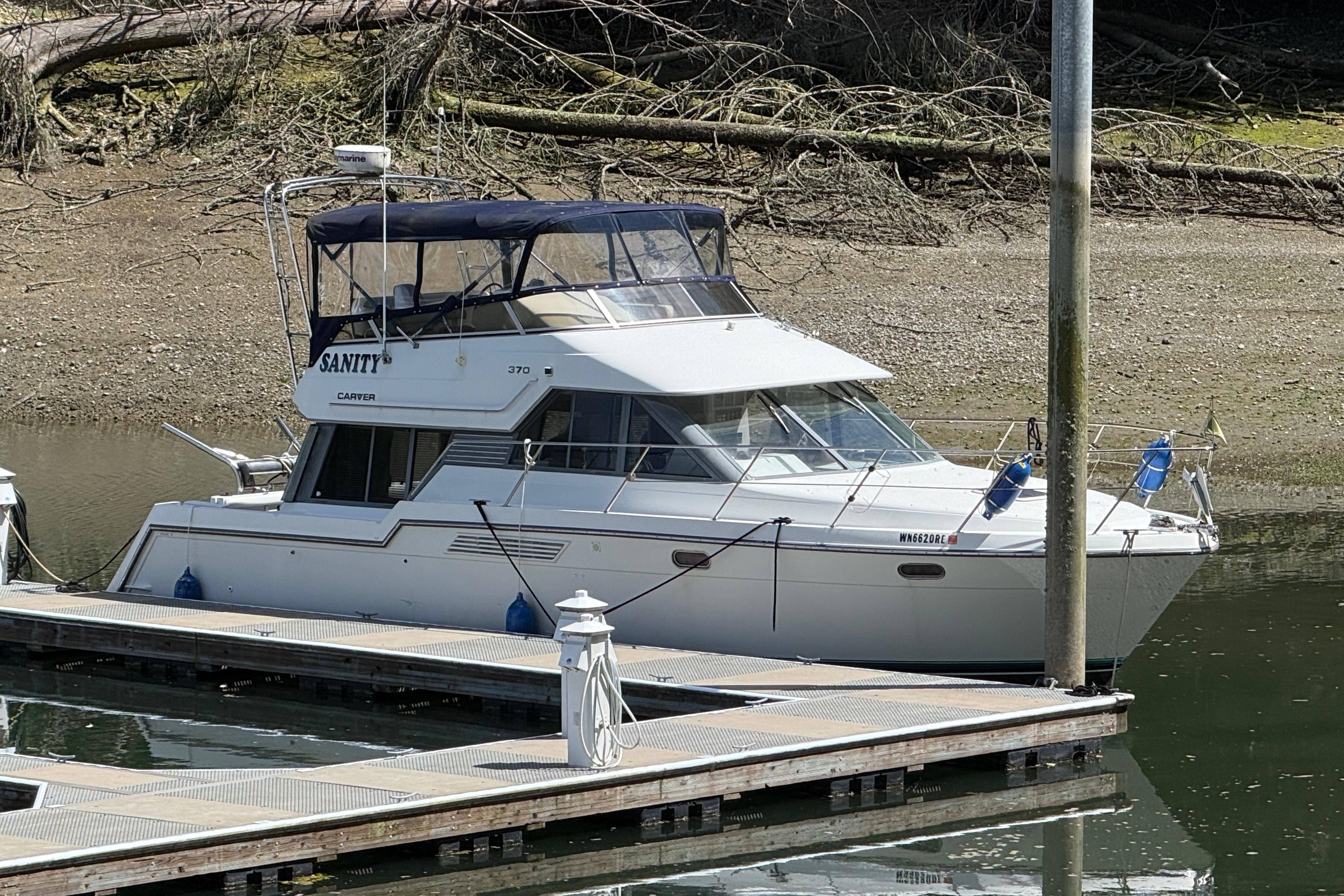 1995 Carver 370 Voyager yacht docked at a marina, featuring a sleek design and spacious cabin.