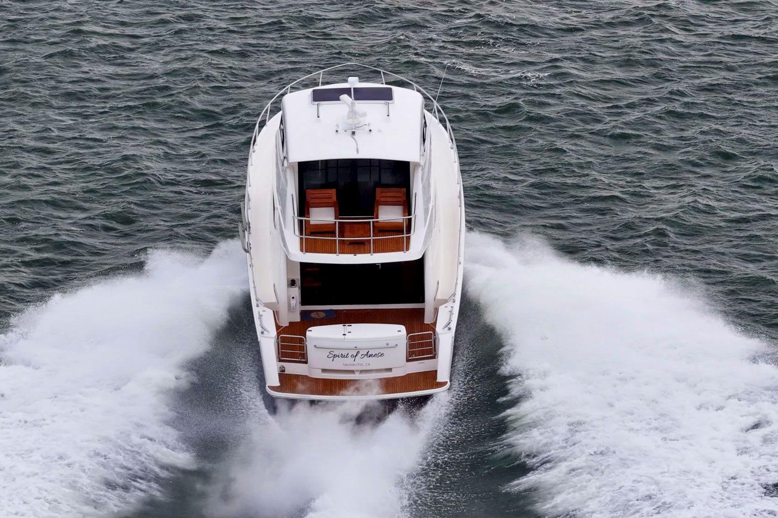 2014 Maritimo M50 yacht cruising on open water, rear view.