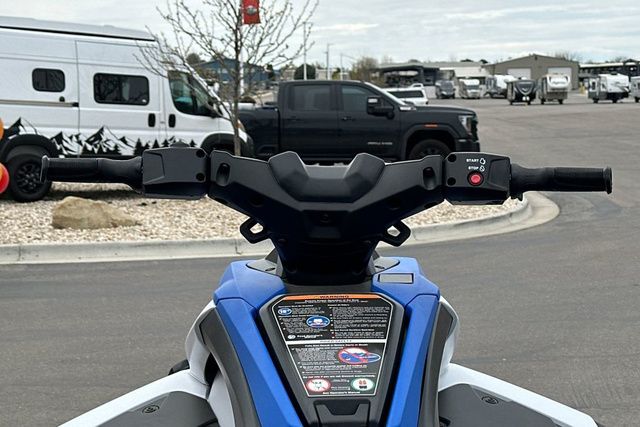 Handlebars of a Yamaha WaveRunner Jetblaster, surrounded by parked vehicles in a lot.
