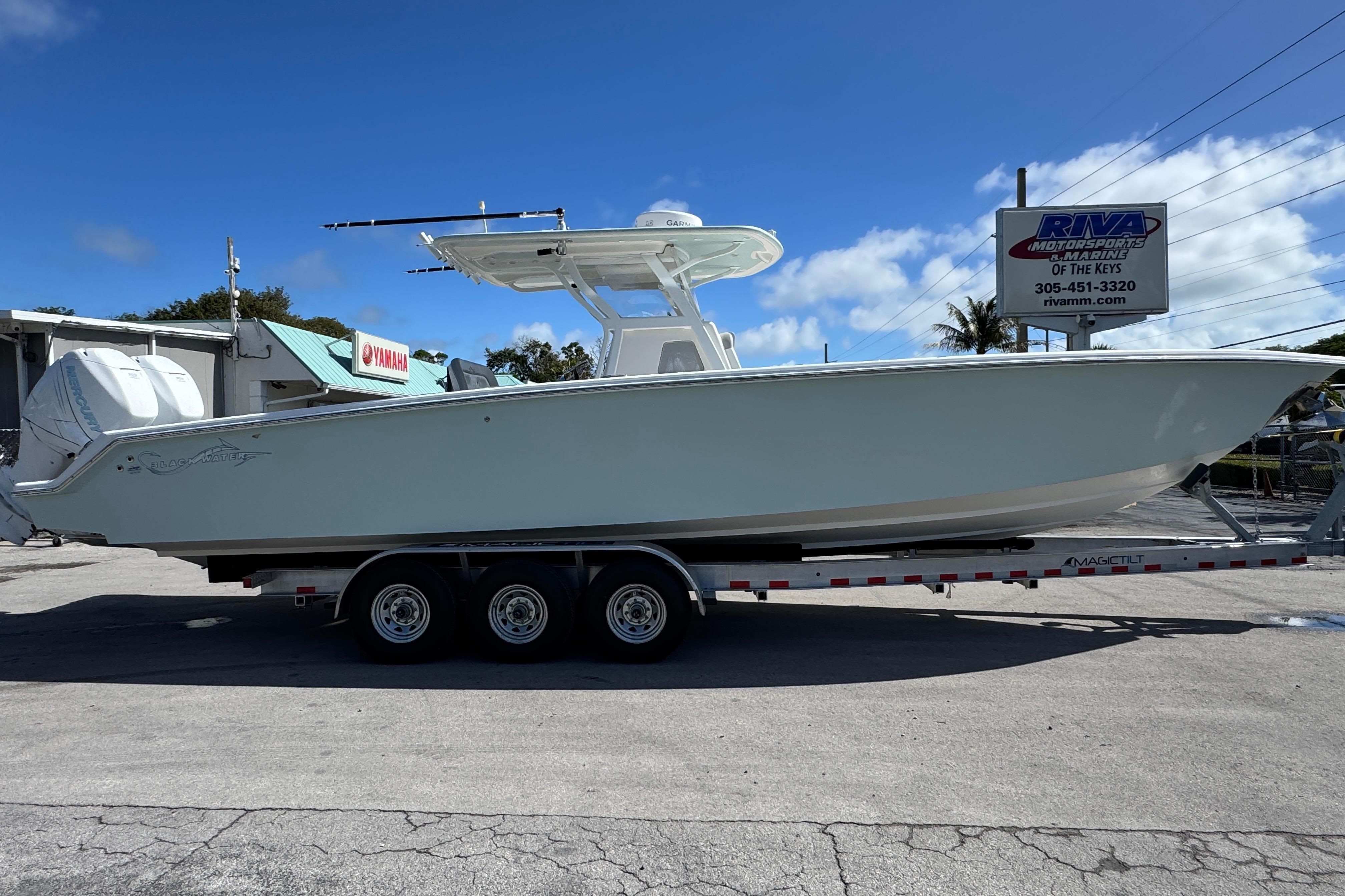 2014 Blackwater 36 Sportfish boat on trailer at dealership under clear blue sky.