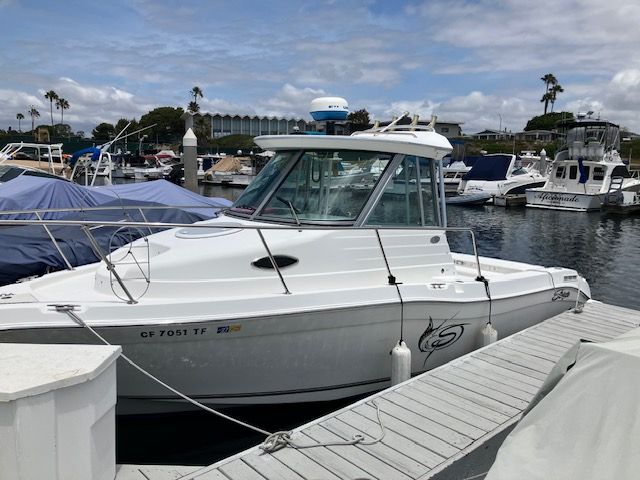 2011 Seaswirl Striper boat docked in marina, cloudy sky.