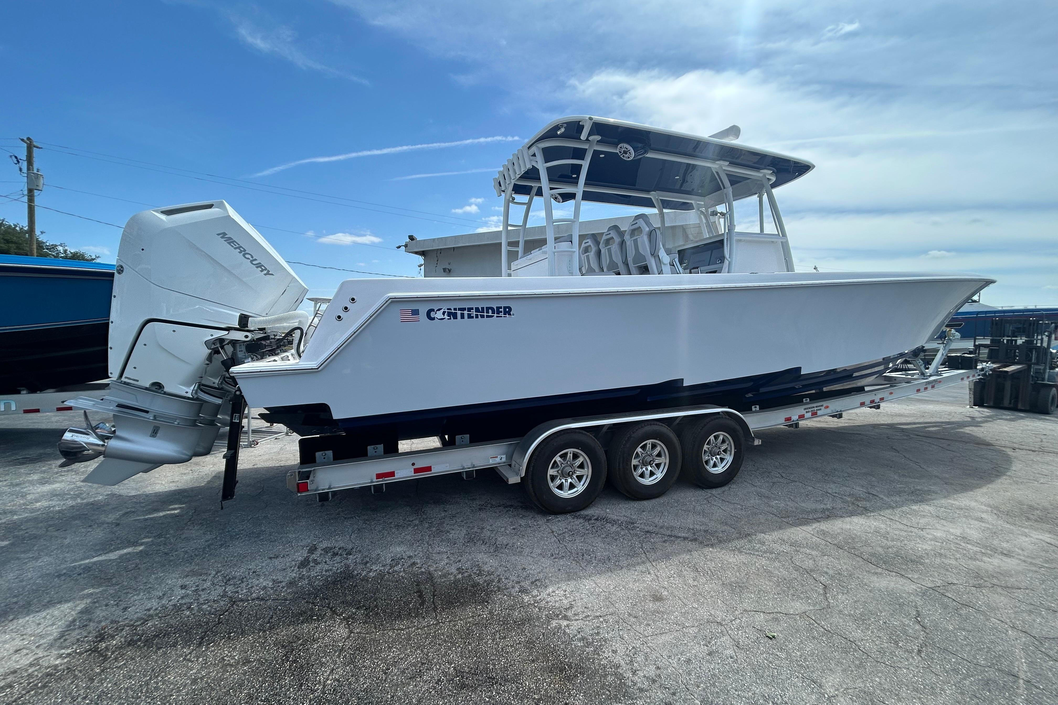 2026 Contender 39 ST boat on trailer with Mercury outboard engines, under clear blue sky.