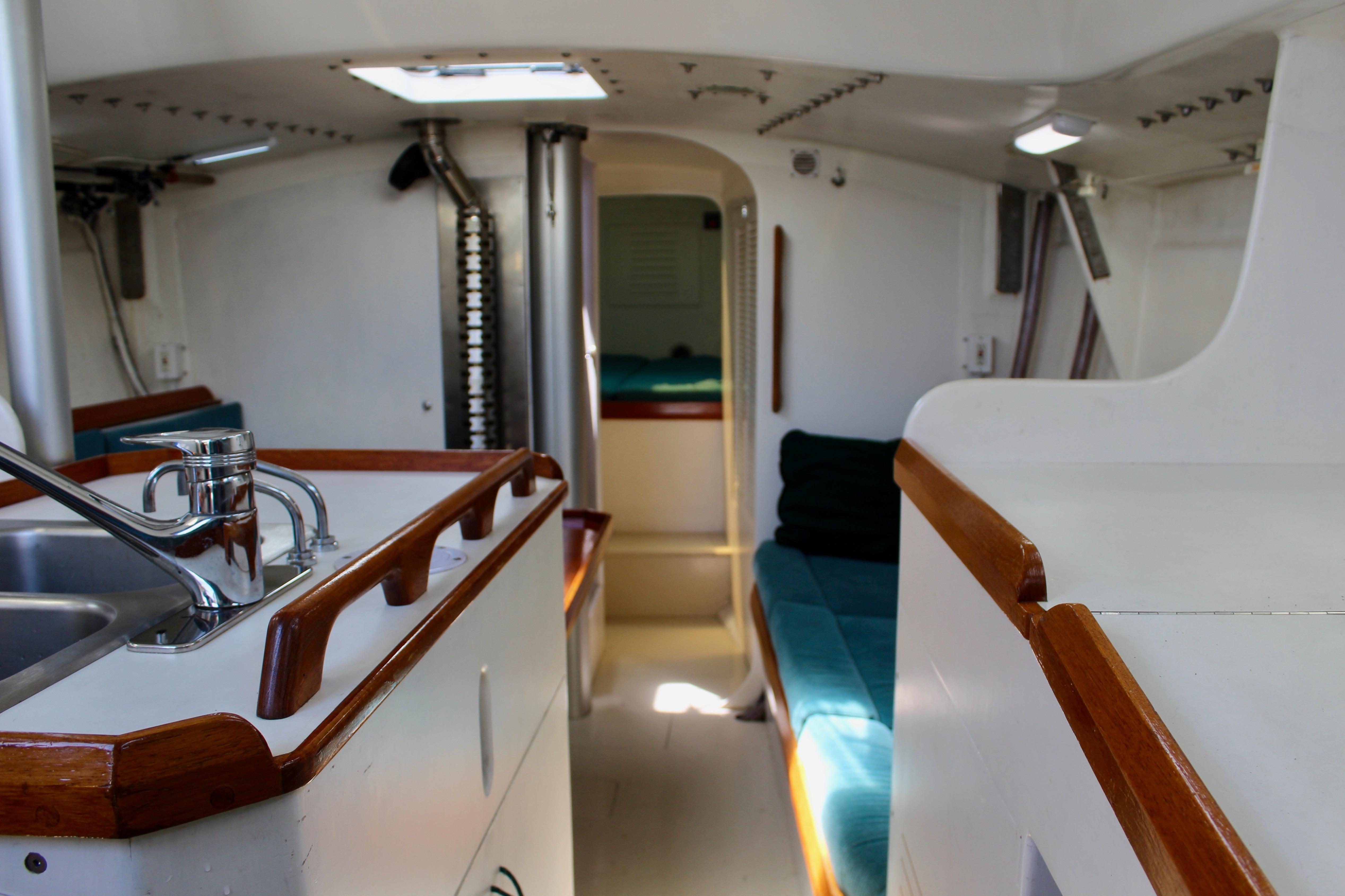 Interior of a 1993 Freya 39 sailboat, featuring a compact kitchen and cozy seating area.