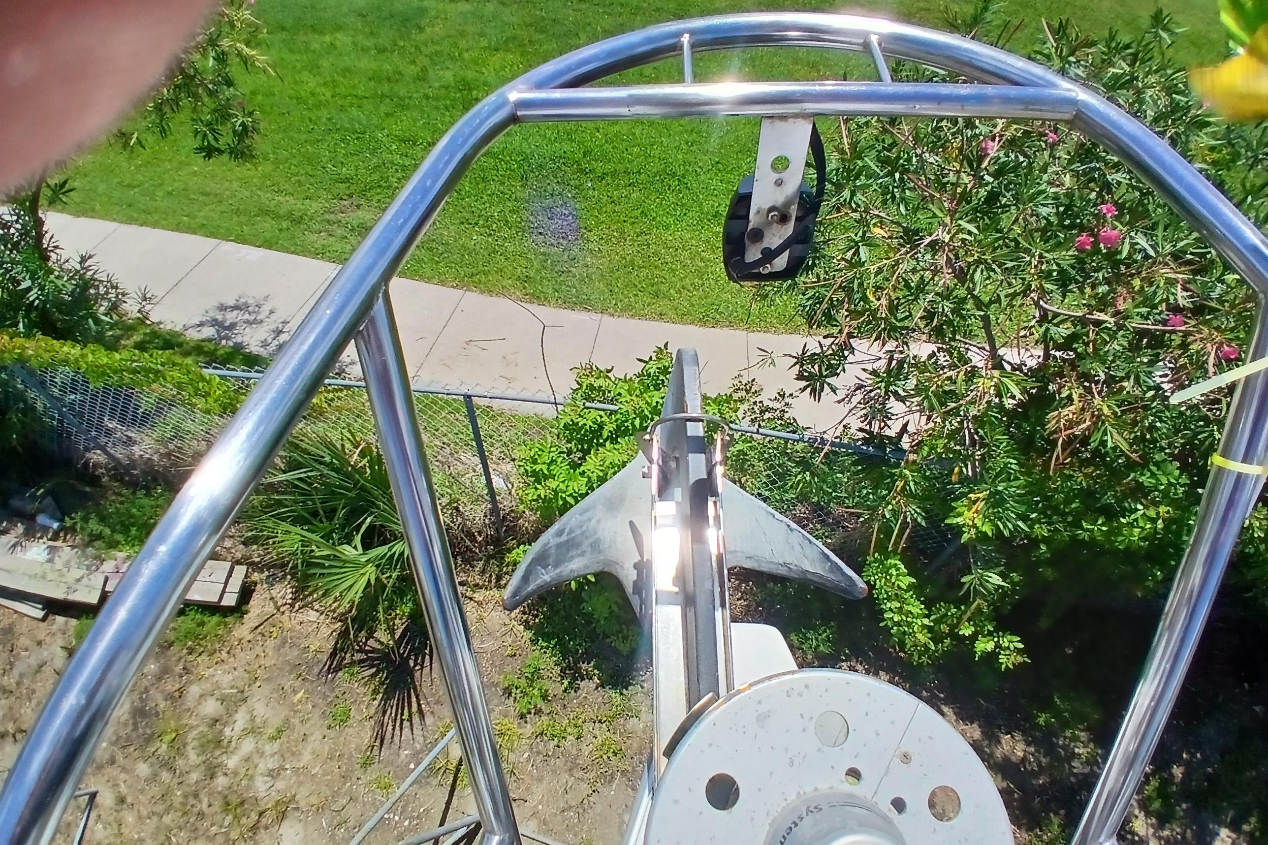 View from Catalina 42 MkII sailboat bow, showcasing anchor and lush greenery.
