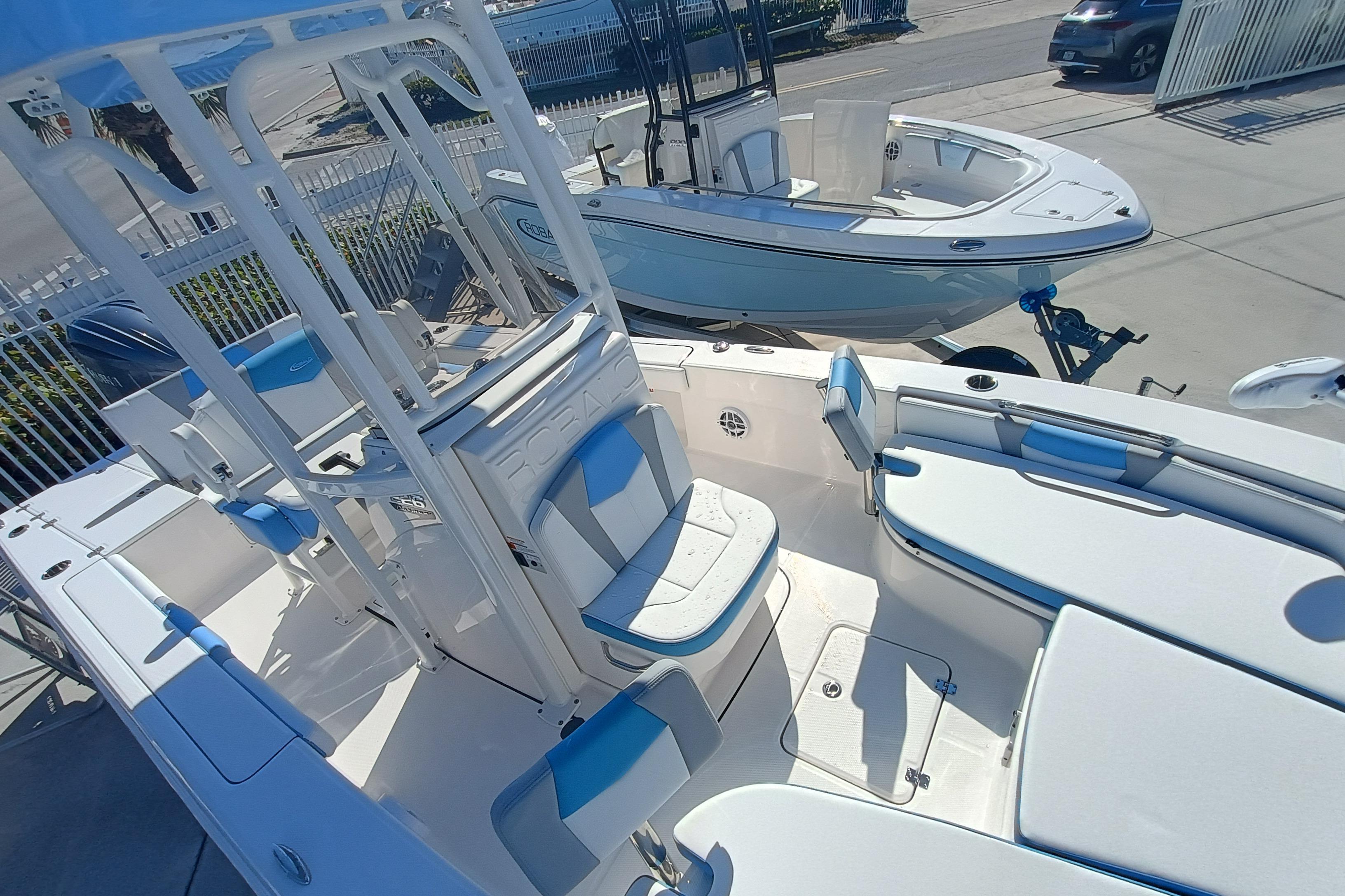 2026 Robalo 226 Cayman boat with blue and white seating, docked outdoors.