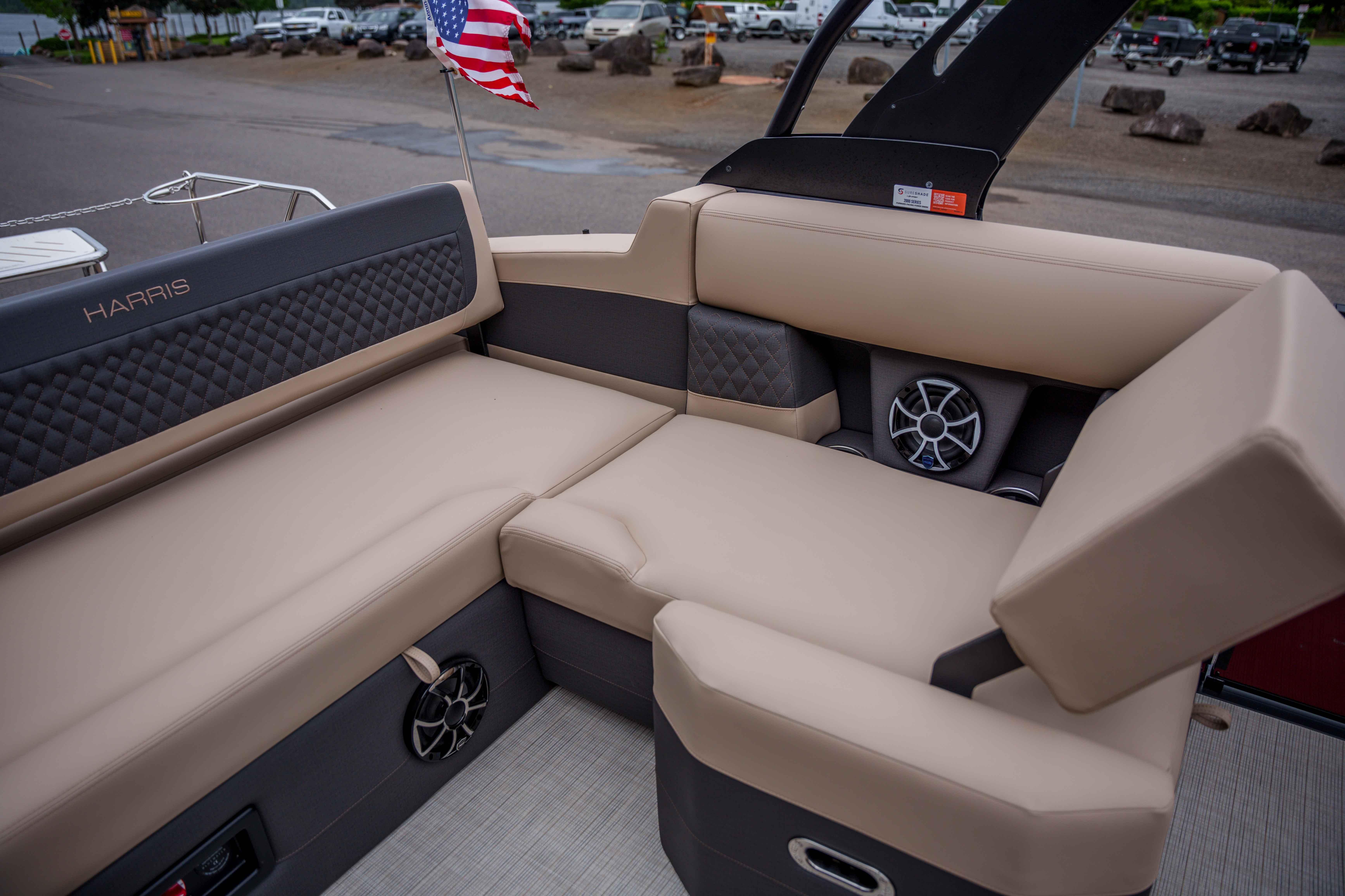 Luxurious seating on 2026 Harris Sunliner 230 boat with premium upholstery and speaker system.