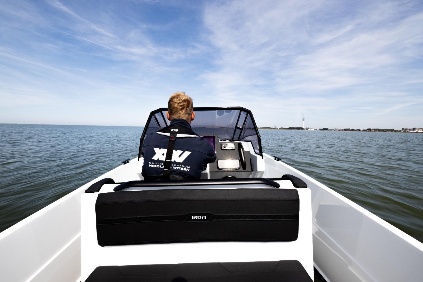 Person steering Iron 707 boat on open water, 2022 model.
