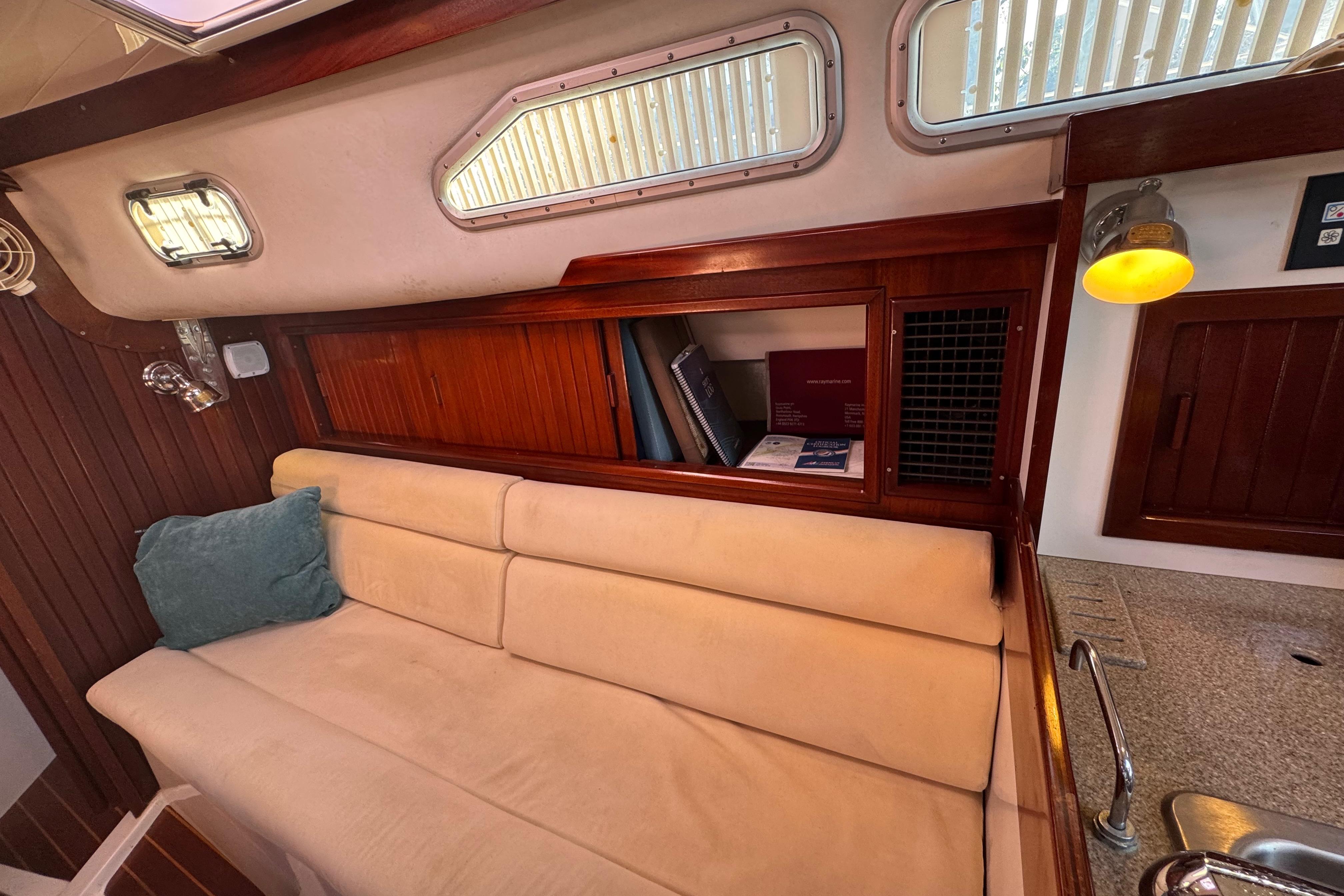 Cozy interior of 2006 Shannon Shoalsailer with beige sofa and wooden accents.