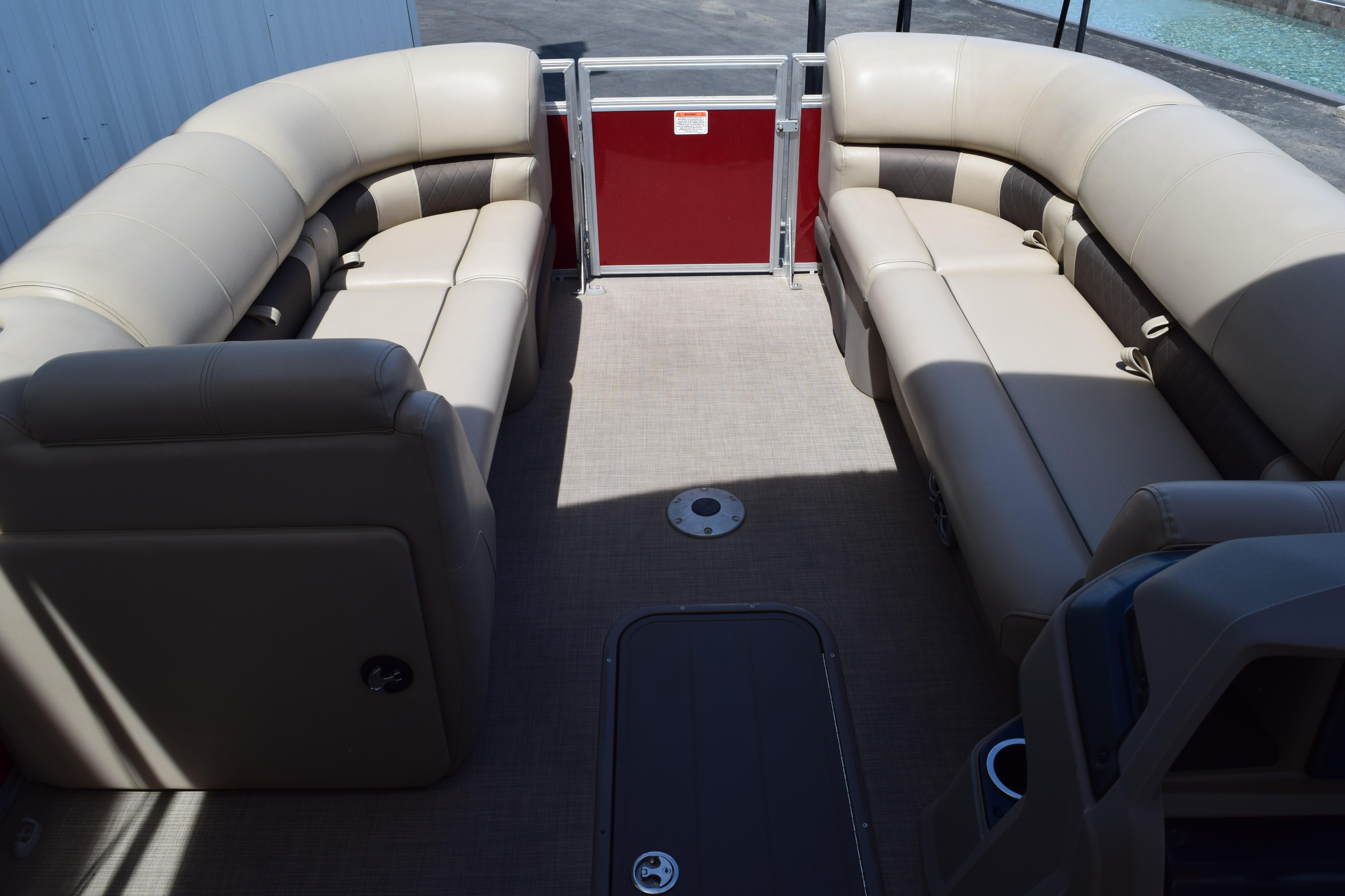 2025 Sun Tracker Party Barge 22 XP3 interior with beige seating and red panel.