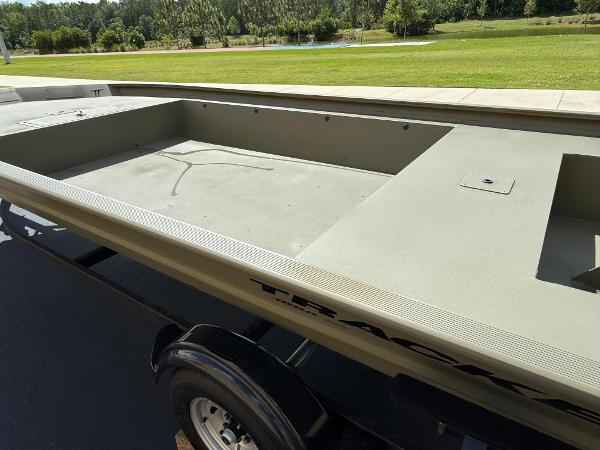 2025 Tracker GRIZZLY 1860 Utility boat on trailer, parked outdoors.