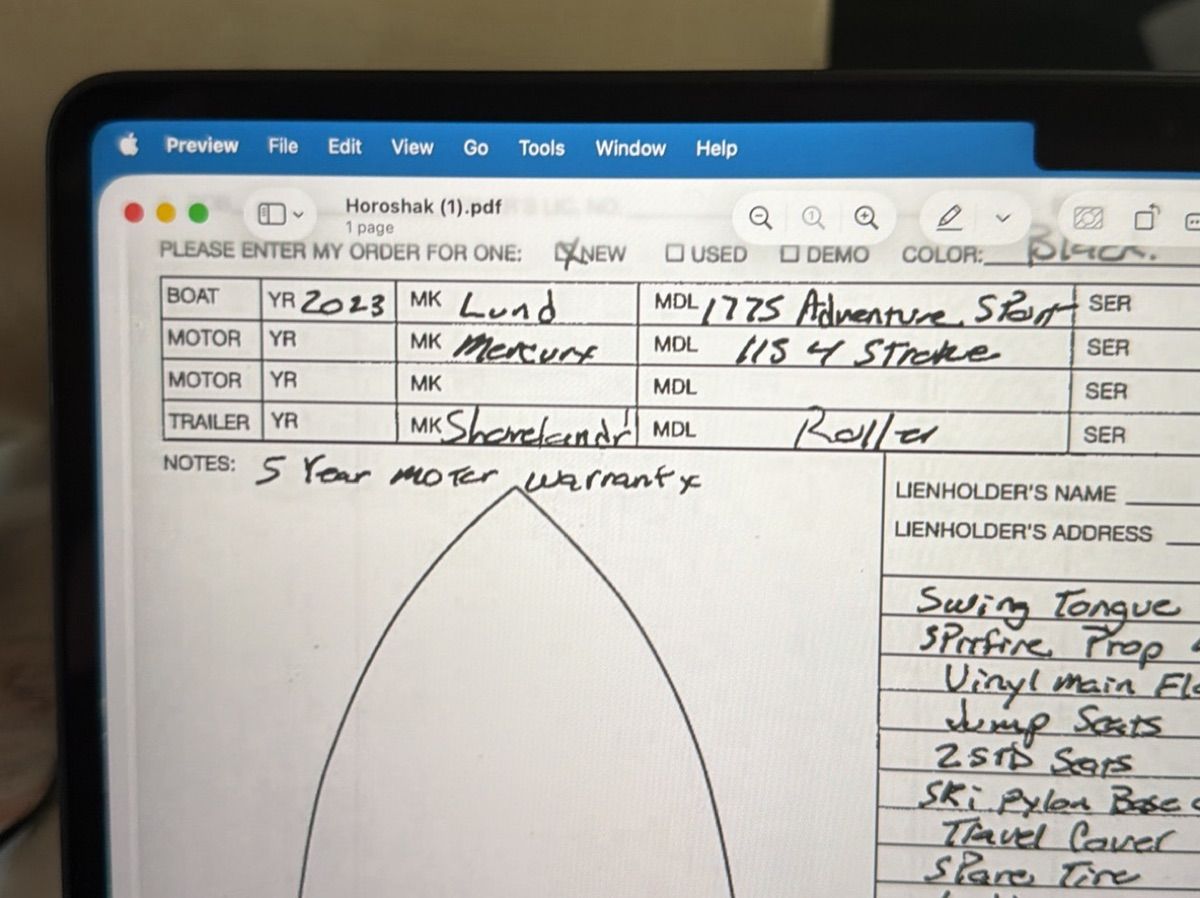 A document on a laptop screen shows details about a boat, including make and model.