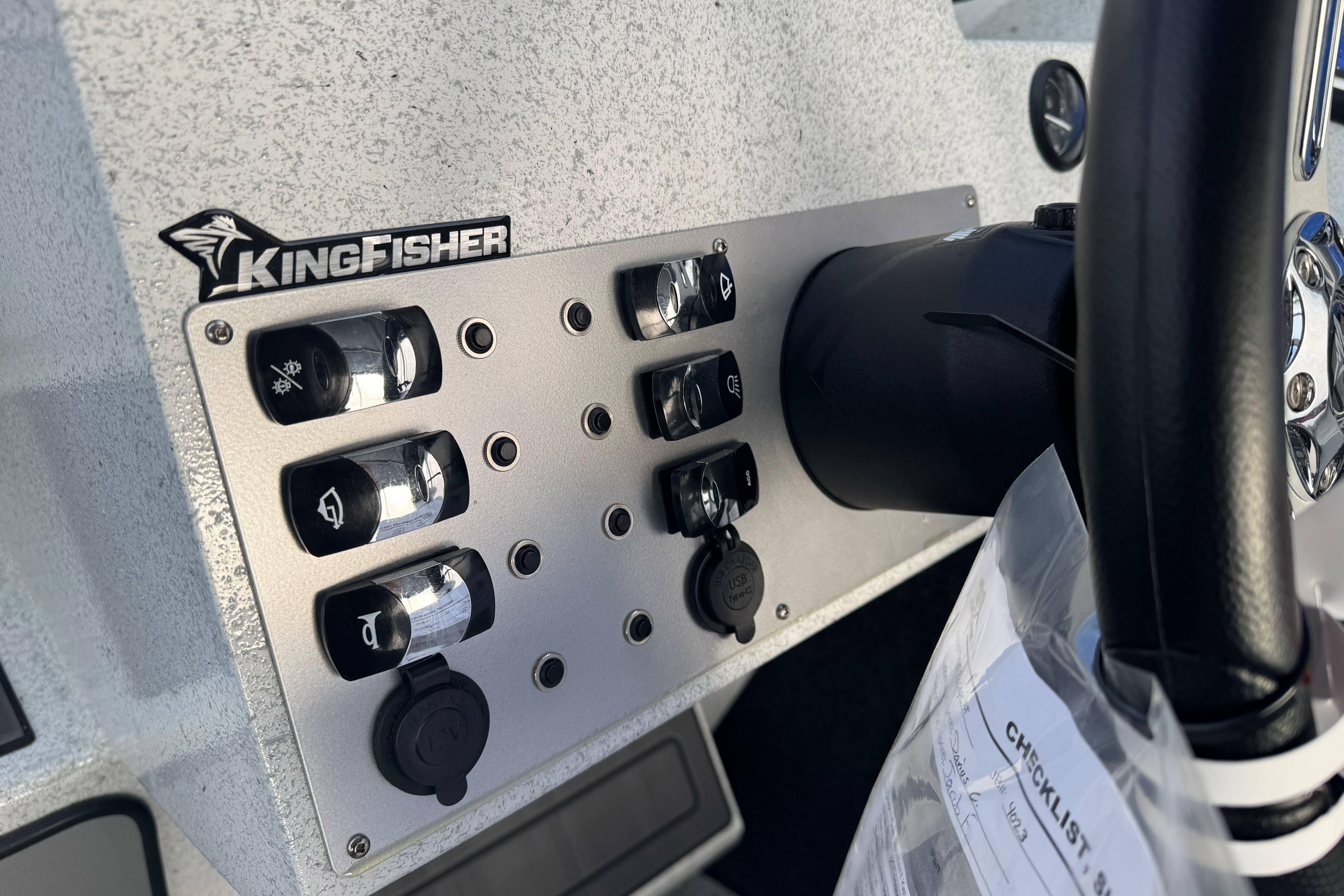 Control panel of 2026 KingFisher Escape boat with switches and steering wheel.