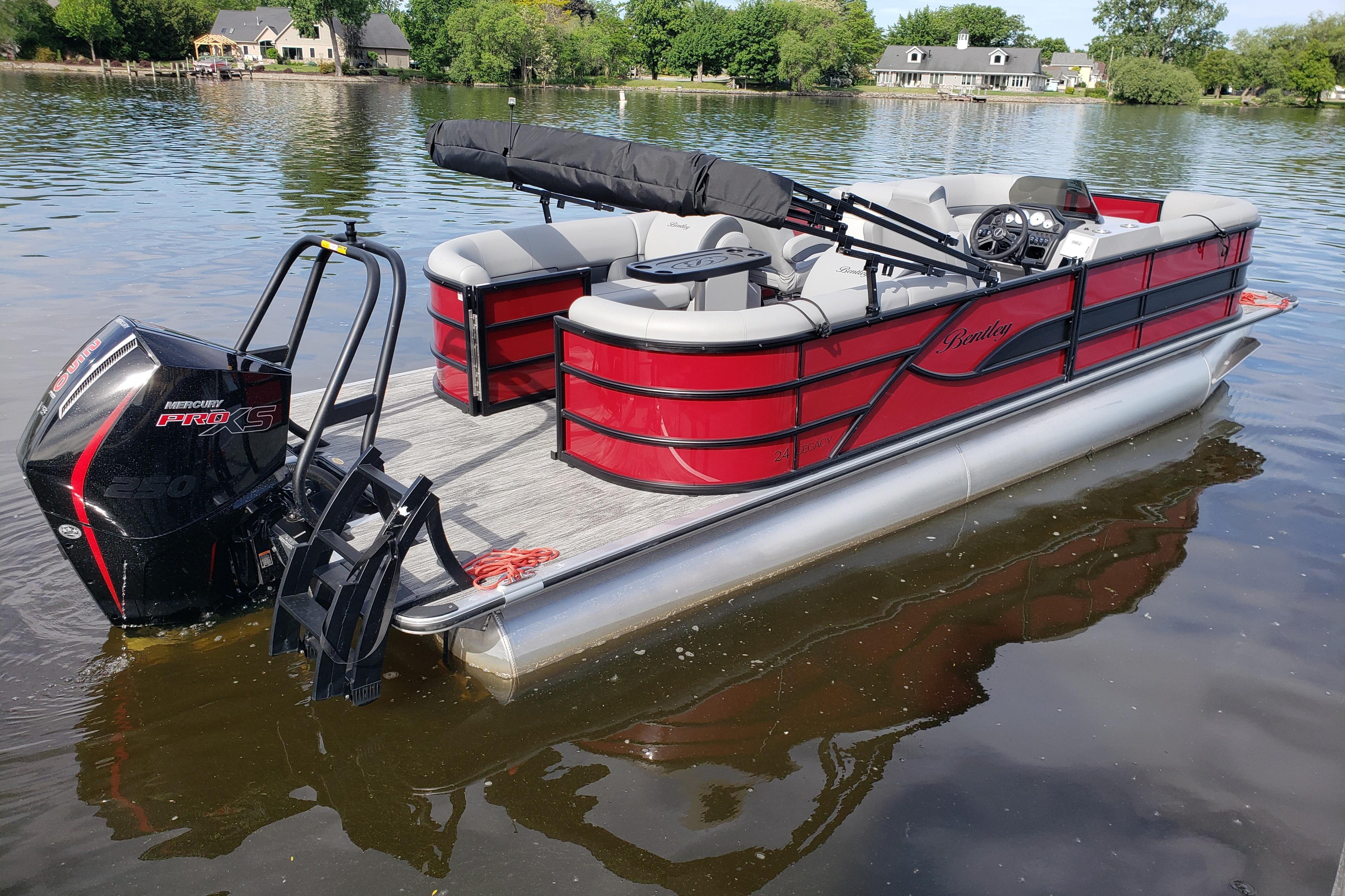 2026 Bentley Pontoons Legacy 243 Navigator Ext on a serene lake.