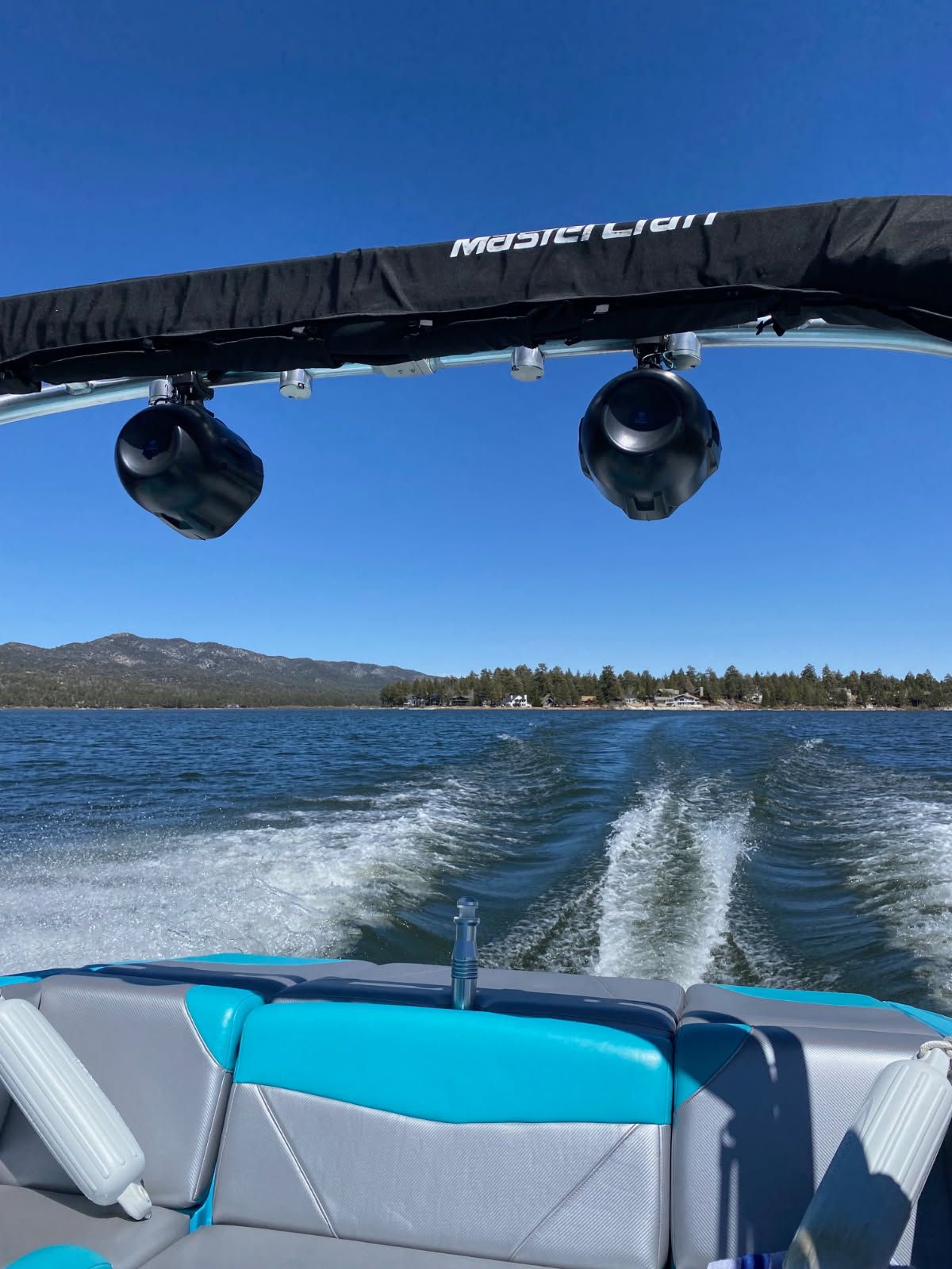 MasterCraft NXT22 boat on a lake, 2021 model, with blue sky.