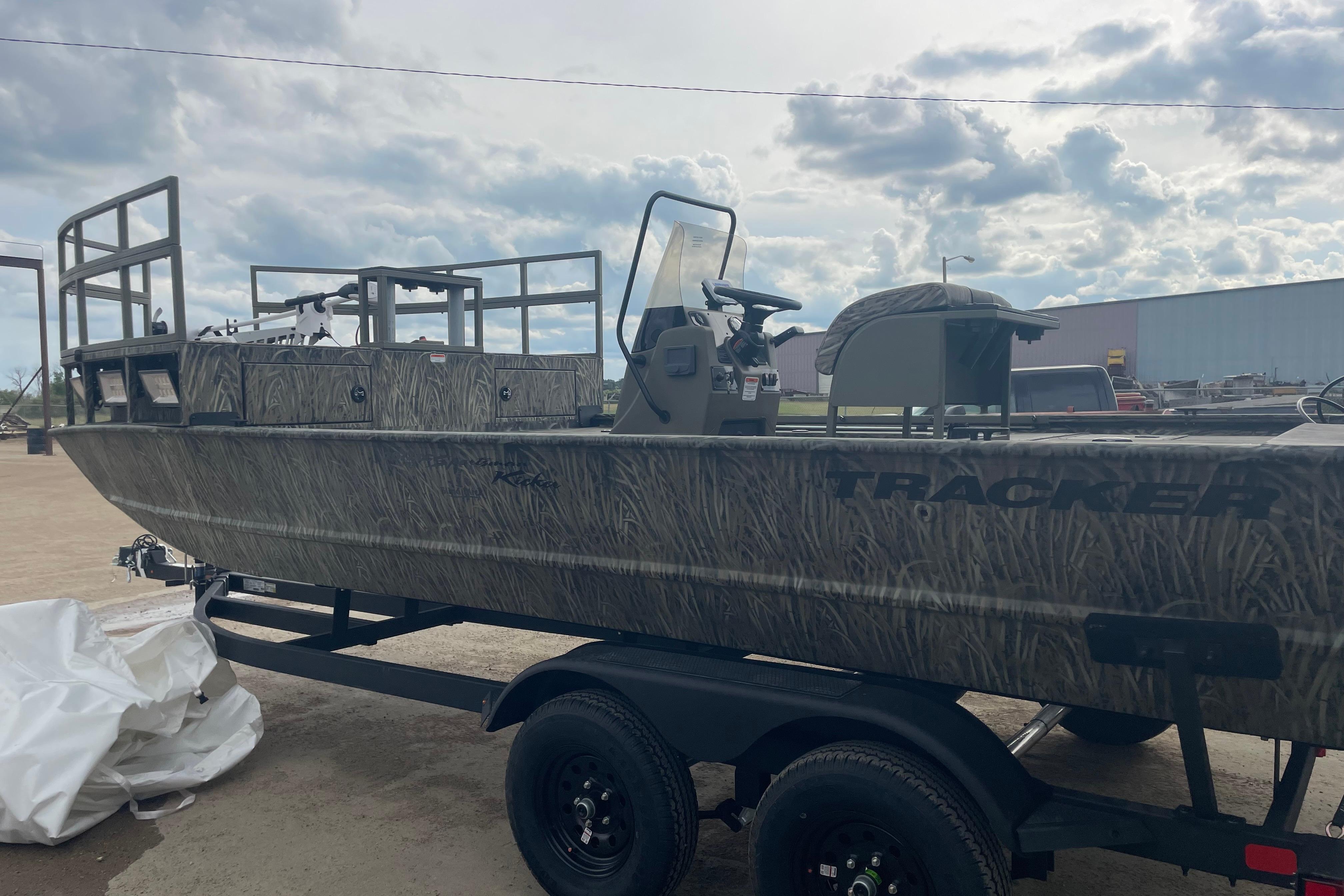 2026 Tracker Grizzly 2072 CC Sportsman Kicker boat on trailer, camo design, outdoor setting.