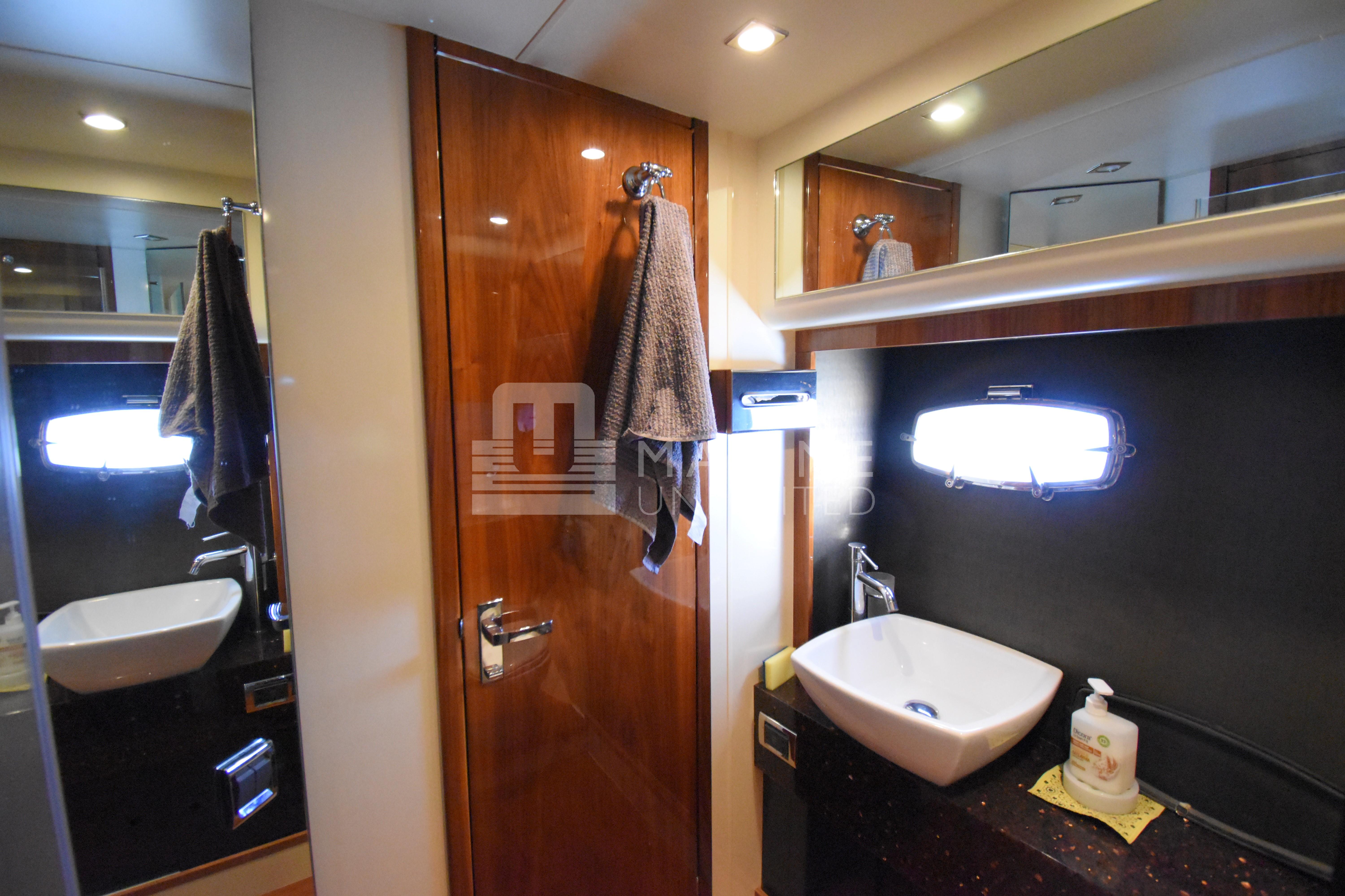 Luxurious bathroom interior of 2010 Fairline Squadron 55 yacht with modern sink and wooden accents.