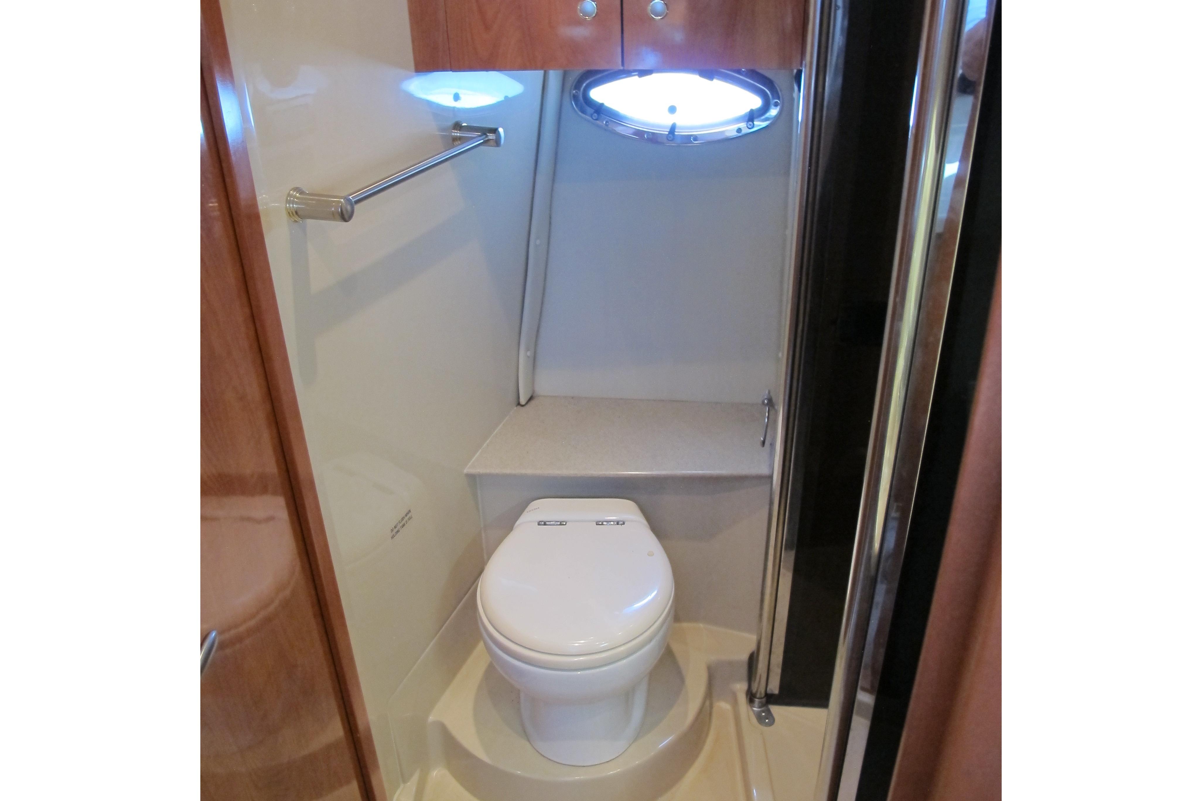 2006 Cruisers Yachts 385 Motoryacht bathroom with toilet and porthole window.